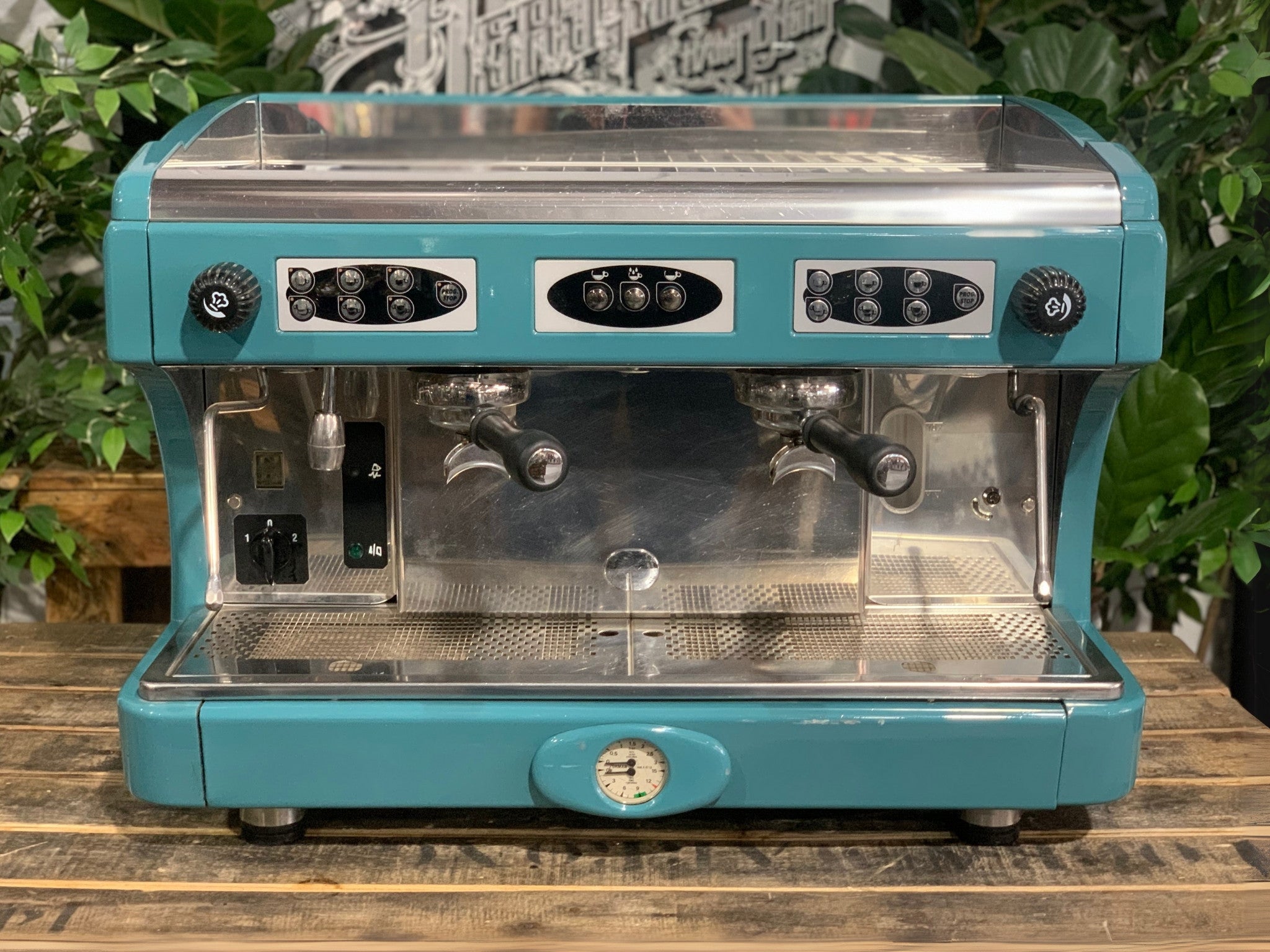 Astoria Calypso 2 Group Aqua Espresso Coffee Machine sitting on a wooden bench. Front on image