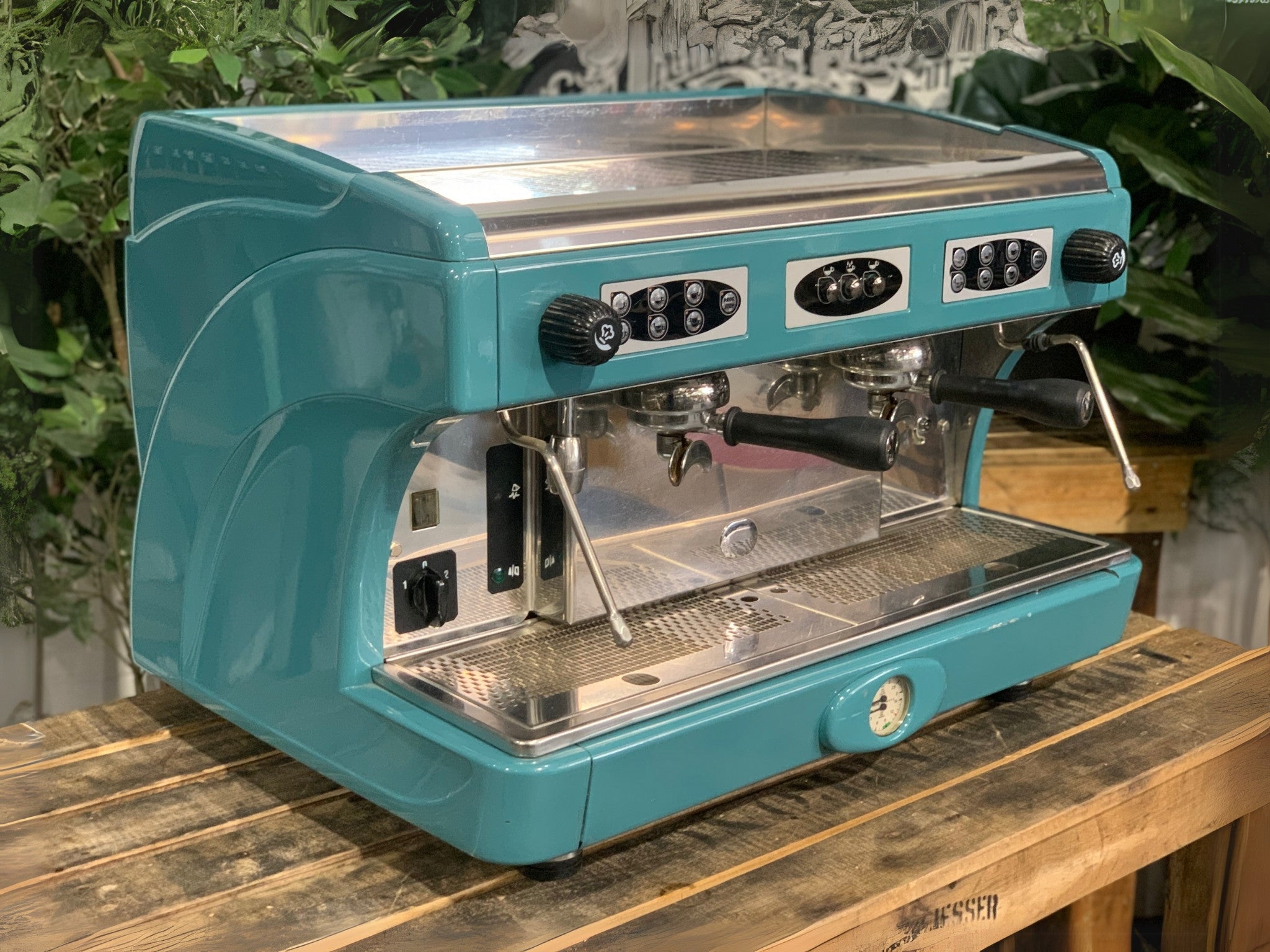 Astoria Calypso 2 Group Aqua Espresso Coffee Machine sitting on a wooden bench. side and front of machine visible