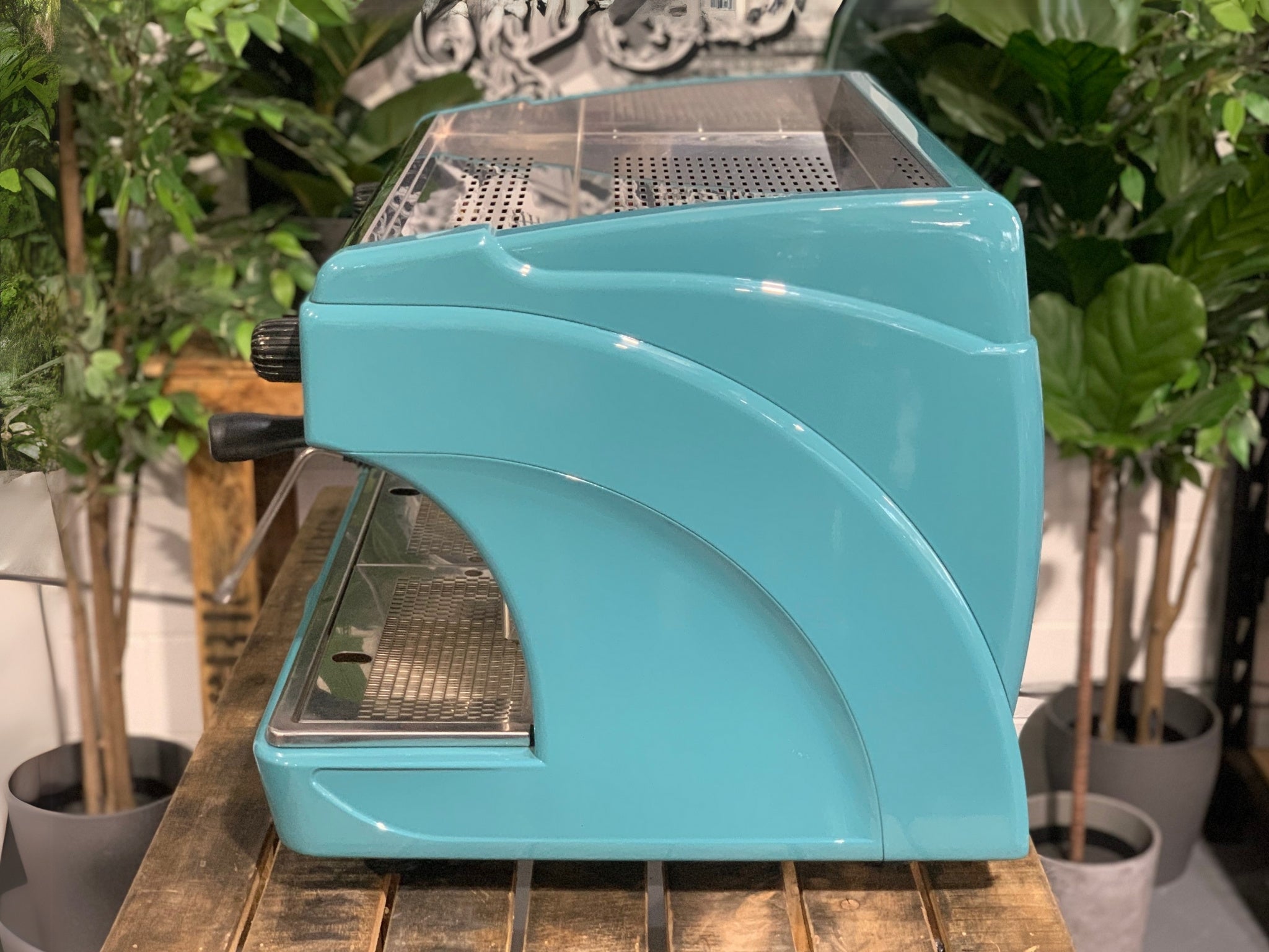 Astoria Calypso 2 Group Aqua Espresso Coffee Machine sitting on a wooden bench. Side of machine