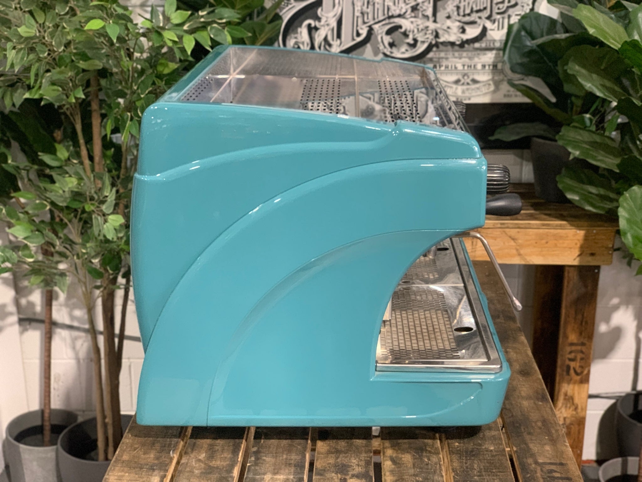 Astoria Calypso 2 Group Aqua Espresso Coffee Machine sitting on a wooden bench. Side of machine.
