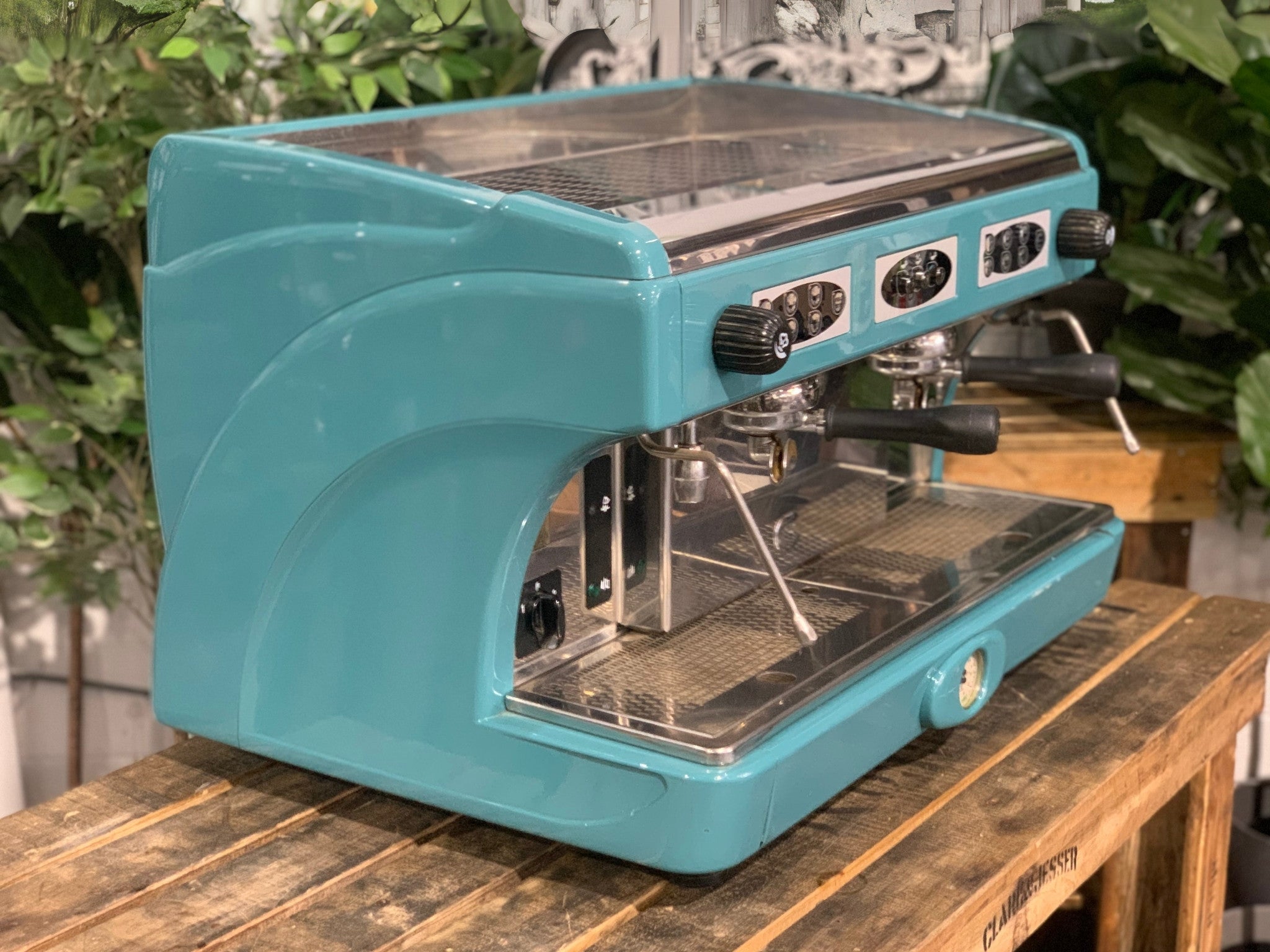 Astoria Calypso 2 Group Aqua Espresso Coffee Machine sitting on a wooden bench. Side view