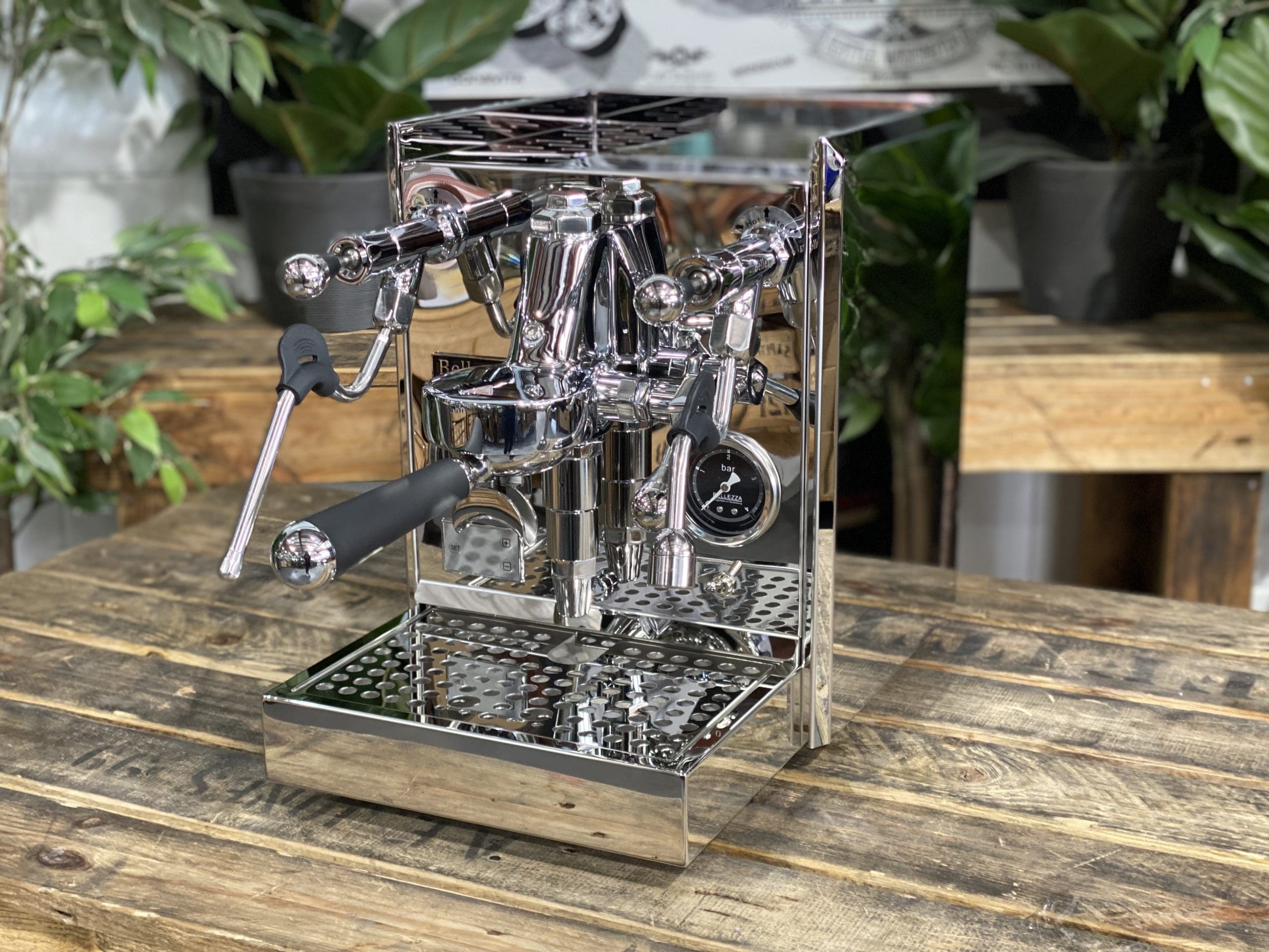 Bellezza Gulia Lever 1 Group Stainless Espresso Machine - New on a wooden table with coffee plants in the background.