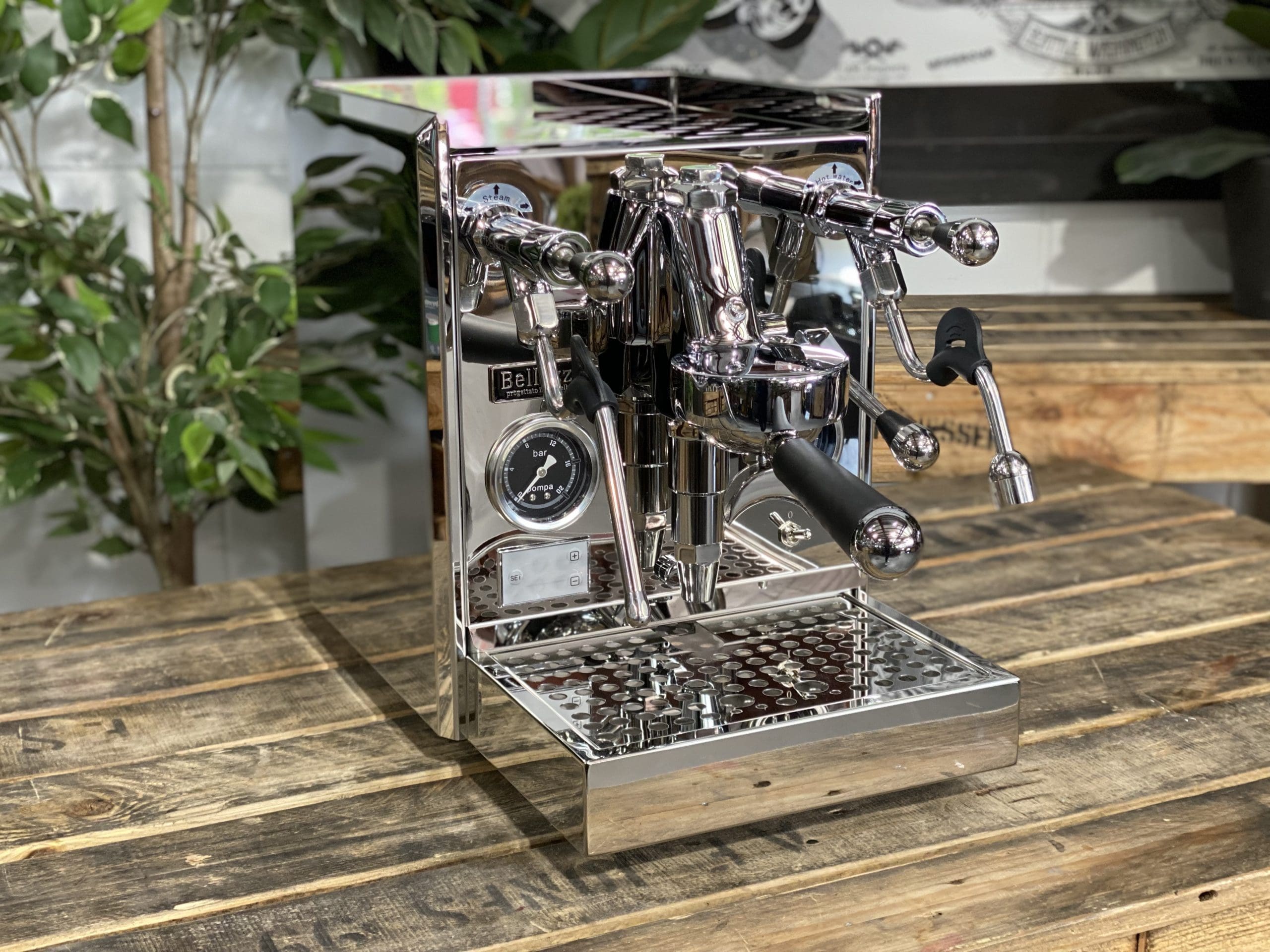Bellezza Gulia Lever 1 Group Stainless Espresso Machine - New on wooden table with plants in background.