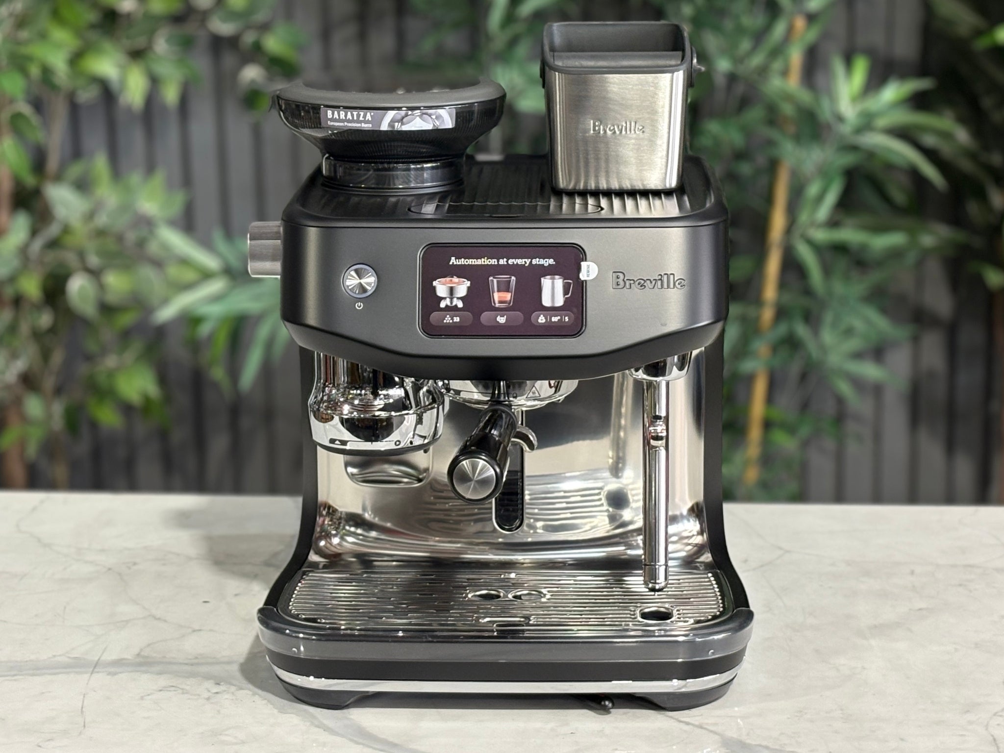 Breville Oracle Jet 1 Group Coffee Machine Black - New, front view on a marble bench, highlighting the 1 group head, AutoMilQ milk steamer, touch screen controls, and black durable body.
