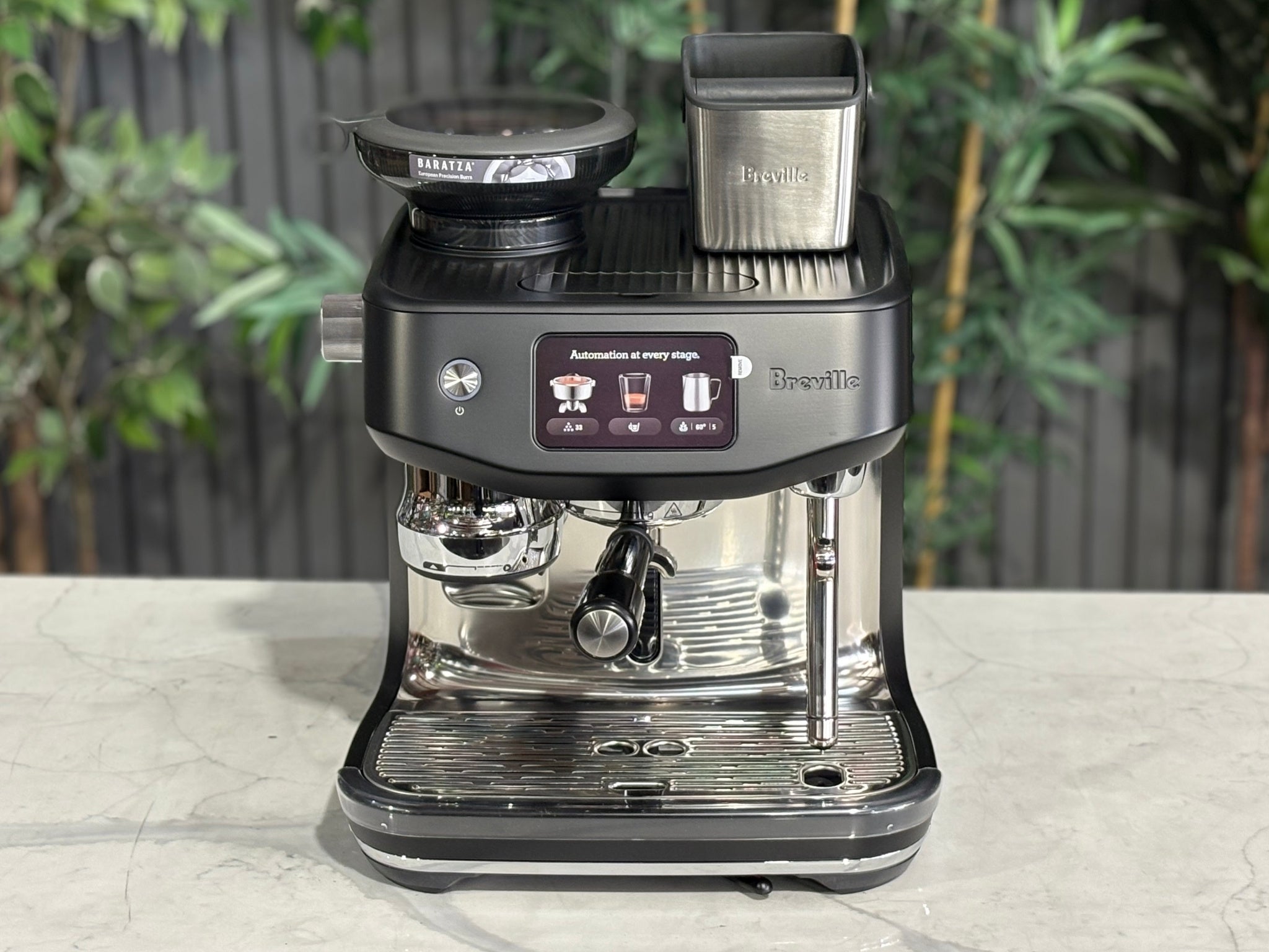 Breville Oracle Jet 1 Group Coffee Machine Black - New, top-front perspective on a marble bench, featuring the 340g coffee hopper, touch screen display, and sleek black body.