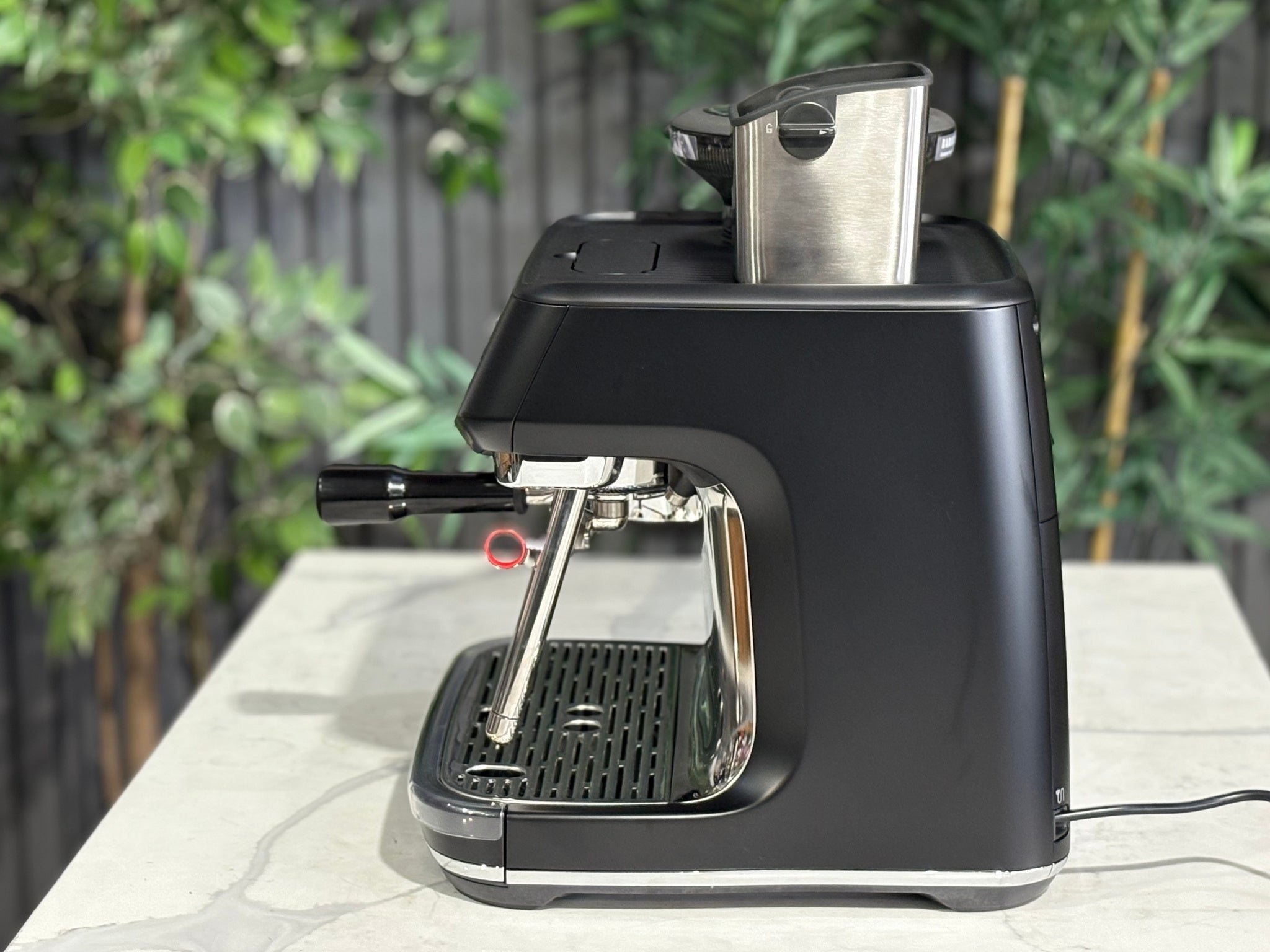 Breville Oracle Jet 1 Group Coffee Machine Black - New, side view on a marble bench, highlighting the black body and AutoMilQ milk steamer wand.