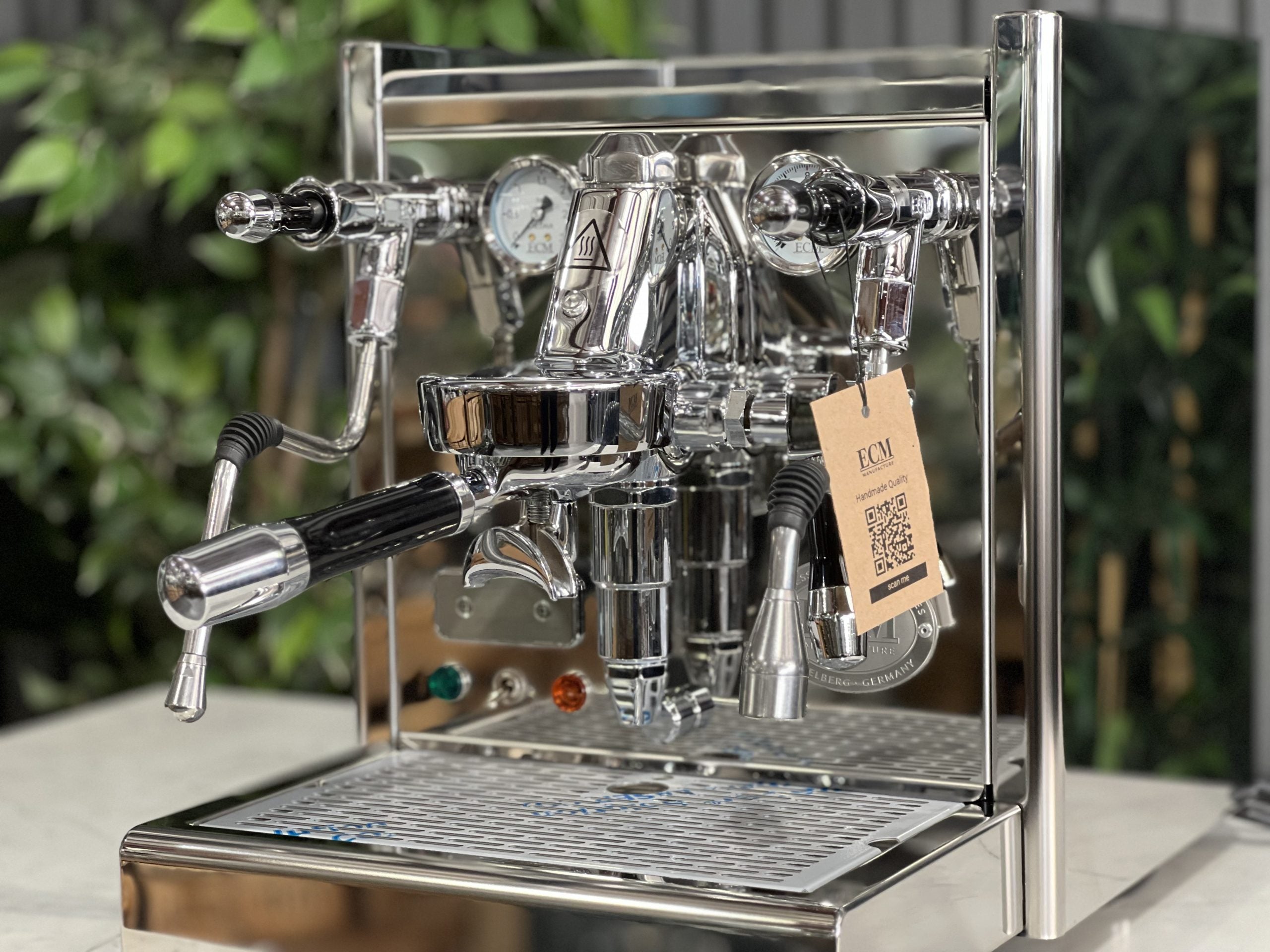 ECM Classika PID 1 Group Coffee Machine Stainless - New espresso coffee machine, close-up front view emphasising the E61 group head, steam wand, and control panel, on a marble surface with leafy plants behind.