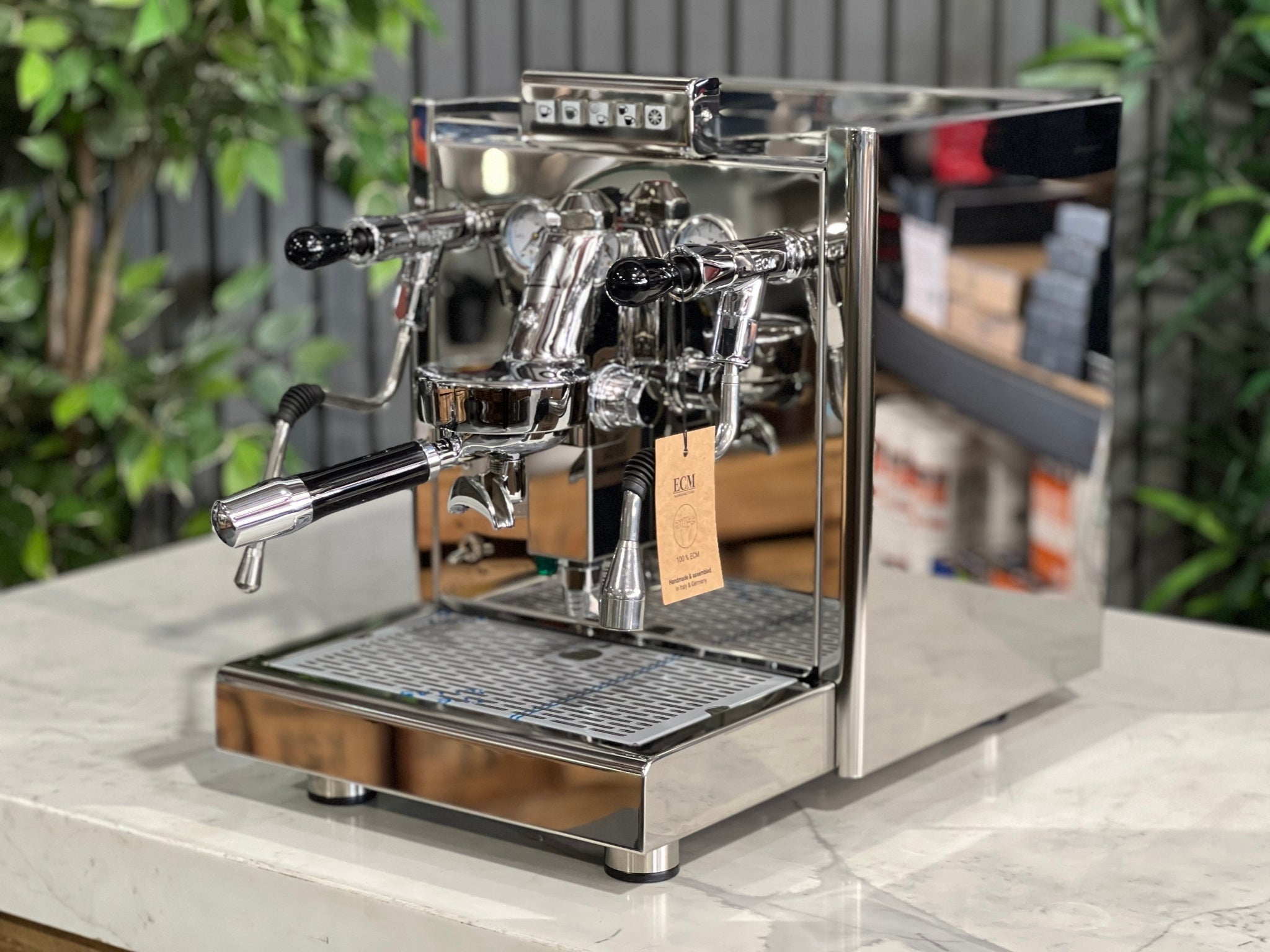 ECM Elektronika II Profi Rotary 1 Group Coffee Machine Stainless – New, angled view showing stainless steel body, E61 group head, steam wand, and cup warmer on a marble bench with greenery behind, perfect for a home espresso setup.