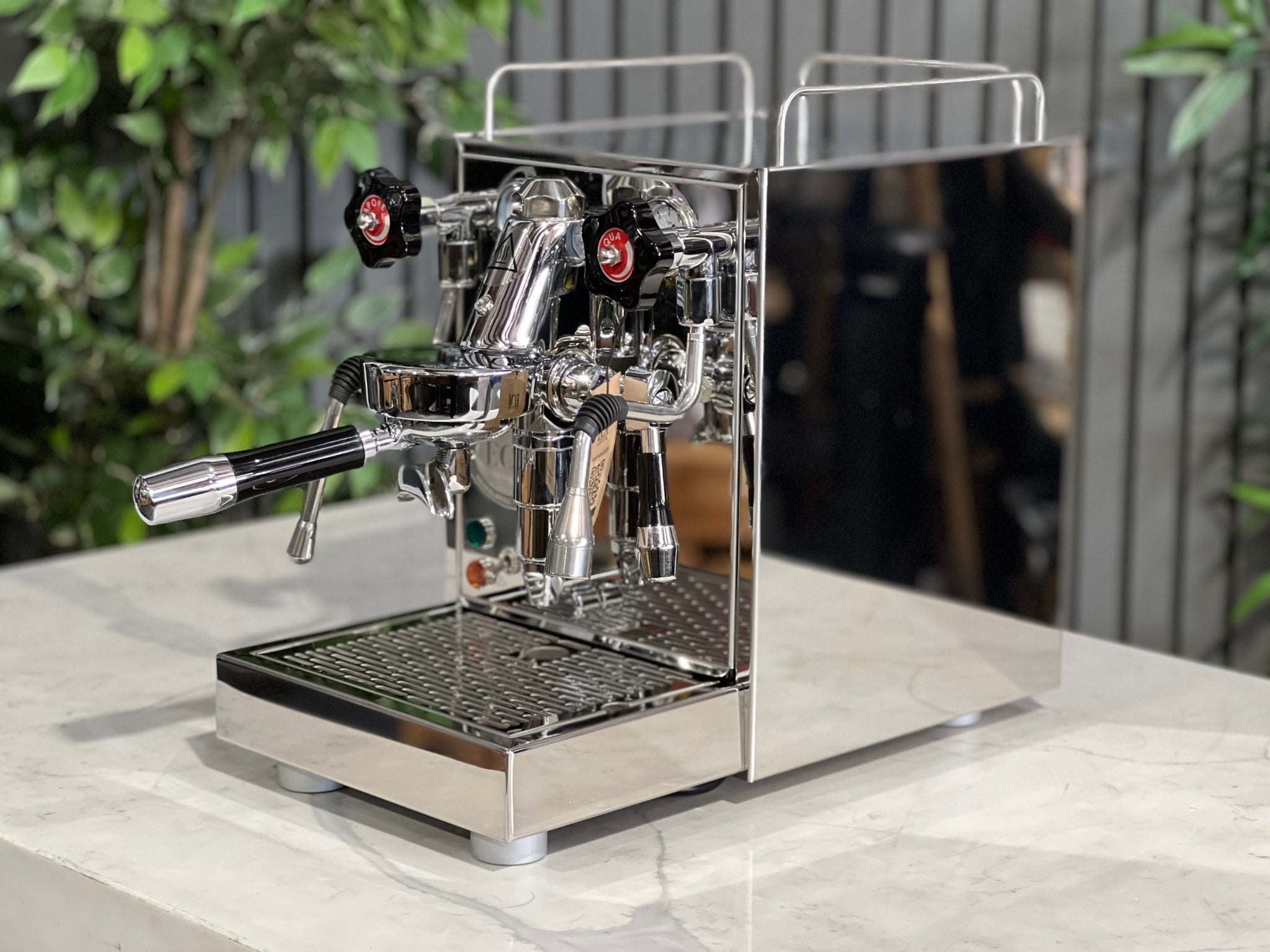 ECM Mechanika VI Slim 1 Group Coffee Machine Stainless on a countertop with greenery in the background.