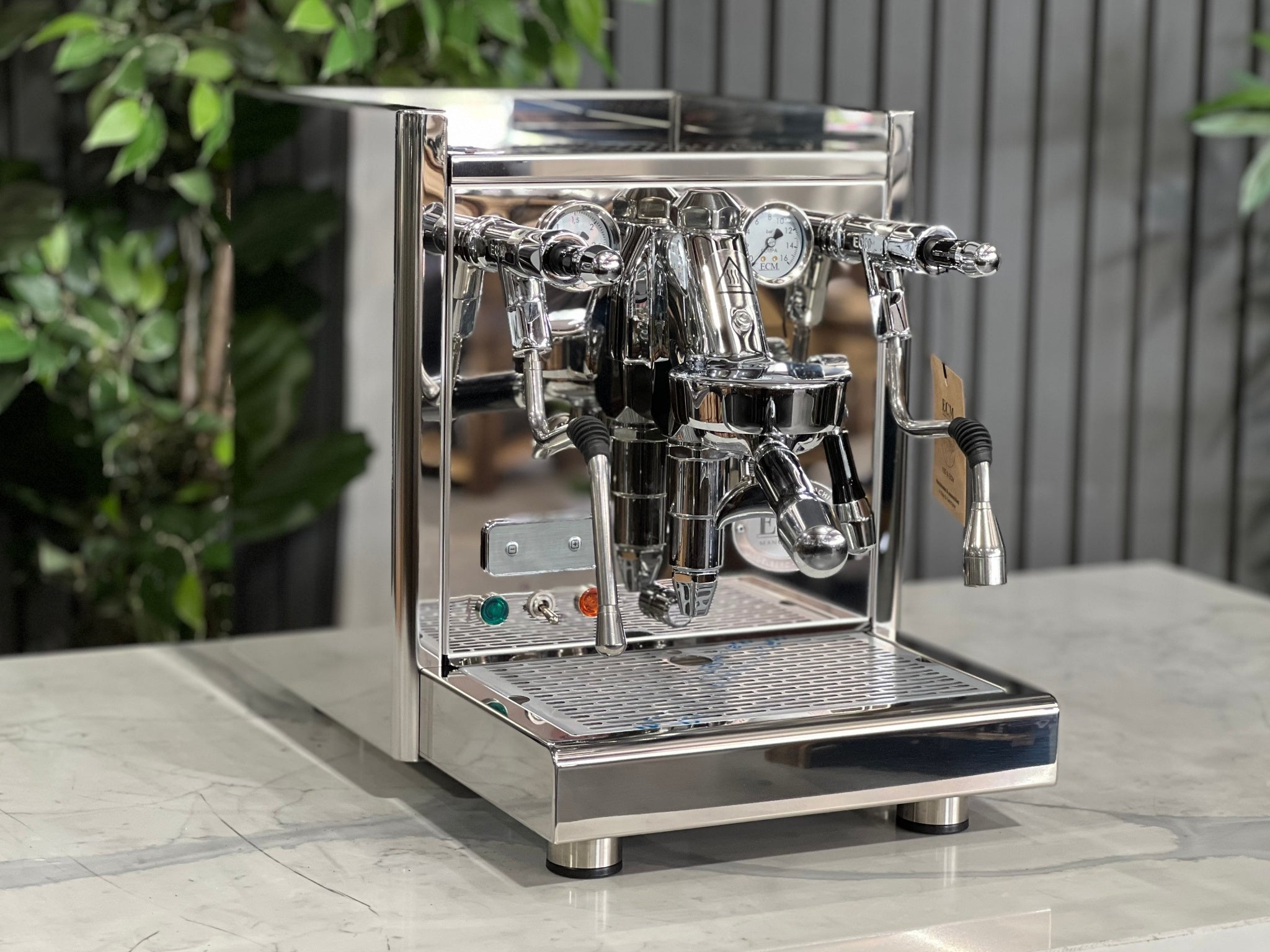 ECM Technika V Profi Rotary PID 1 Group Coffee Machine Stainless – New espresso coffee machine shown at an angled view on a white marble bench with greenery behind, displaying the E61 group head, dual gauges, and stainless steam wand.