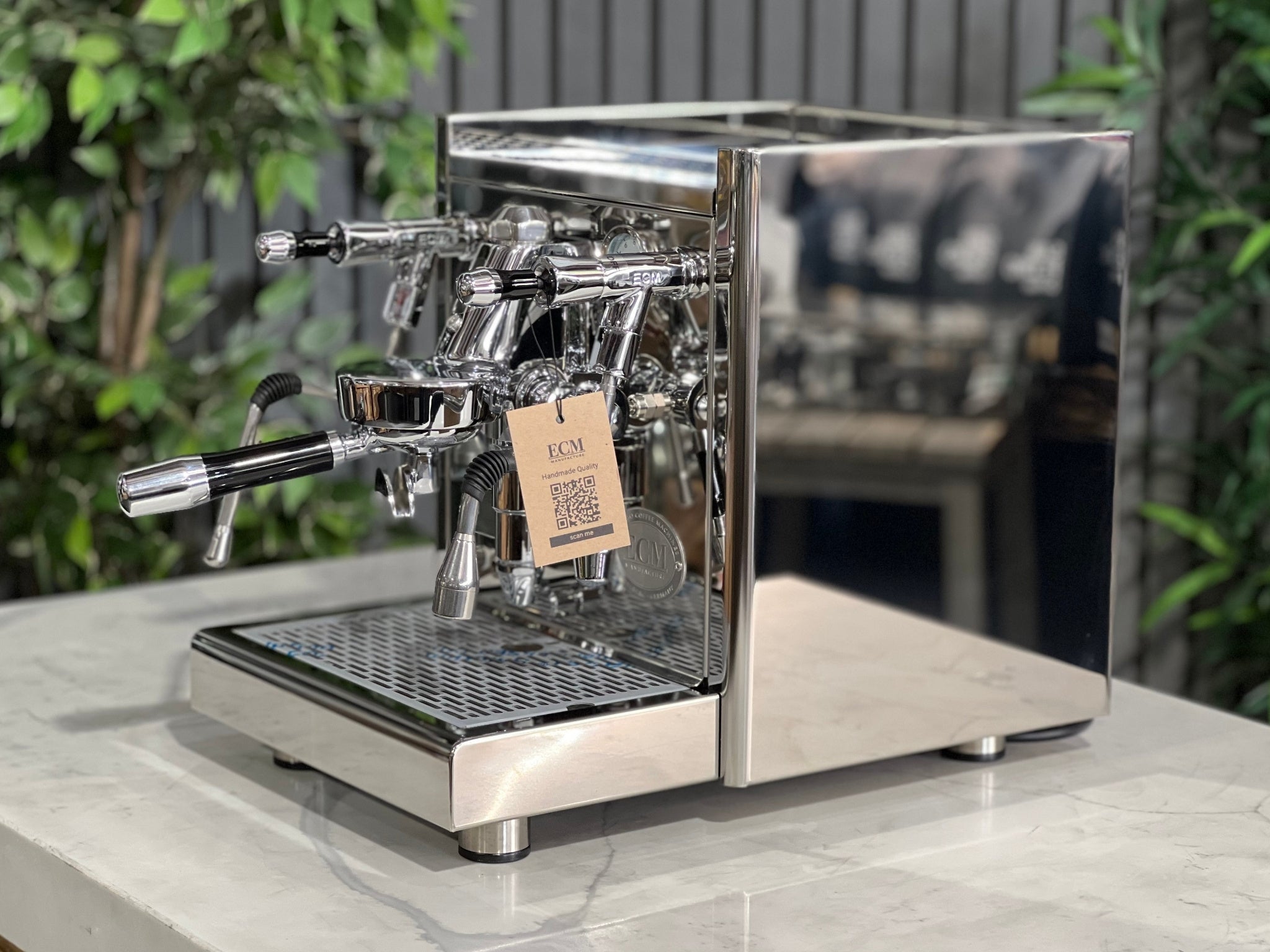 ECM Technika V Profi Rotary PID 1 Group Coffee Machine Stainless – New espresso coffee machine shown at an angled view on a white marble bench with greenery behind, displaying the E61 group head, dual gauges, and stainless steam wand.