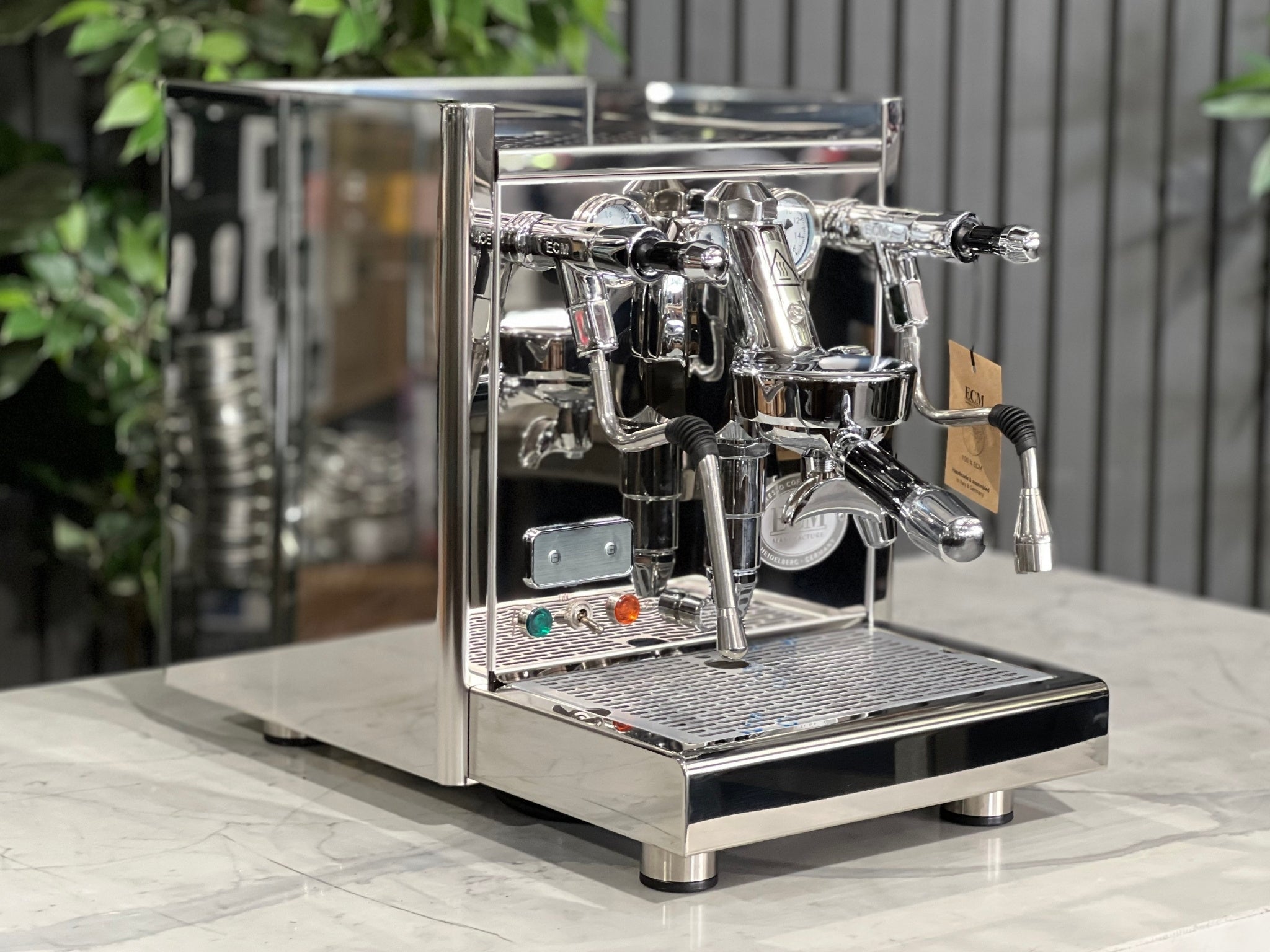 ECM Technika V Profi Rotary PID 1 Group Coffee Machine Stainless – New espresso coffee machine shown at an angled view on a white marble bench with greenery behind, displaying the E61 group head, dual gauges, and stainless steam wand.