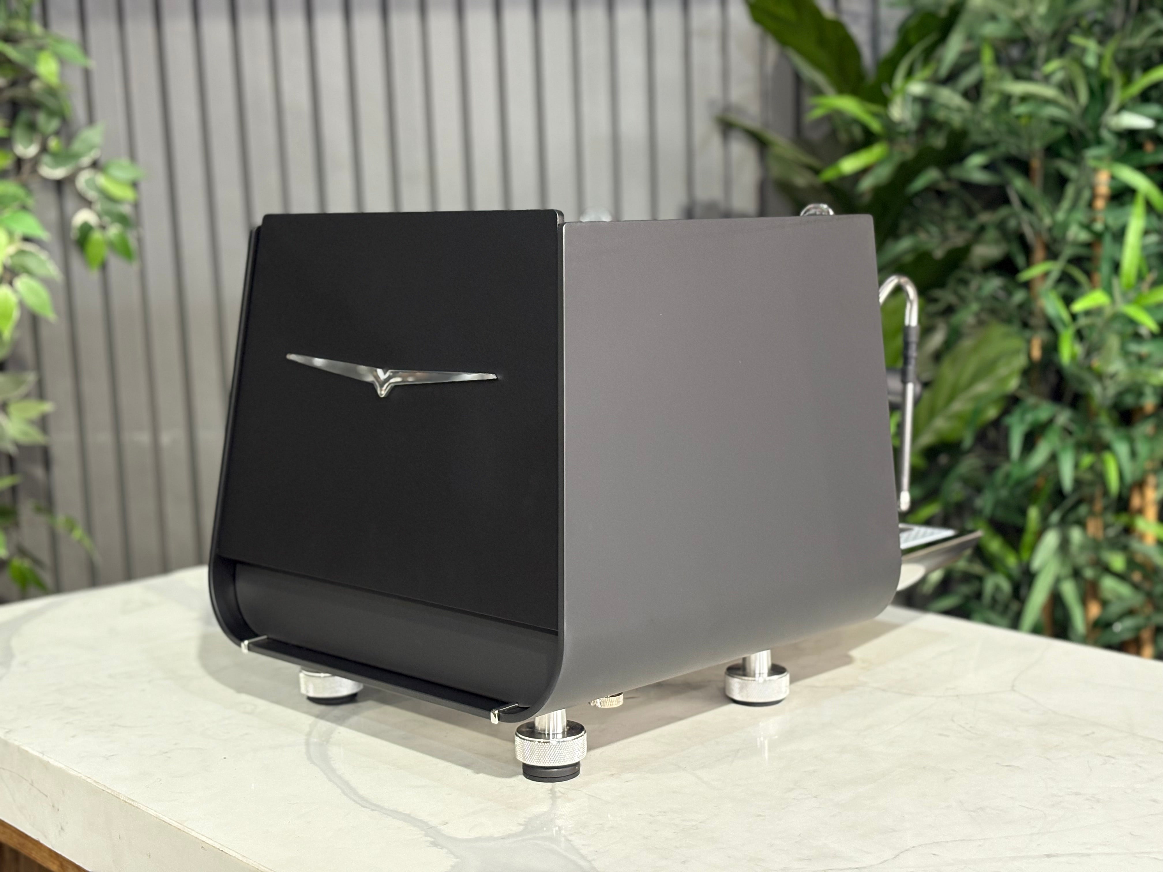 Victoria Arduino Eagle One Prima 1 Group Coffee Machine Black - New on a marble surface with greenery in the background.