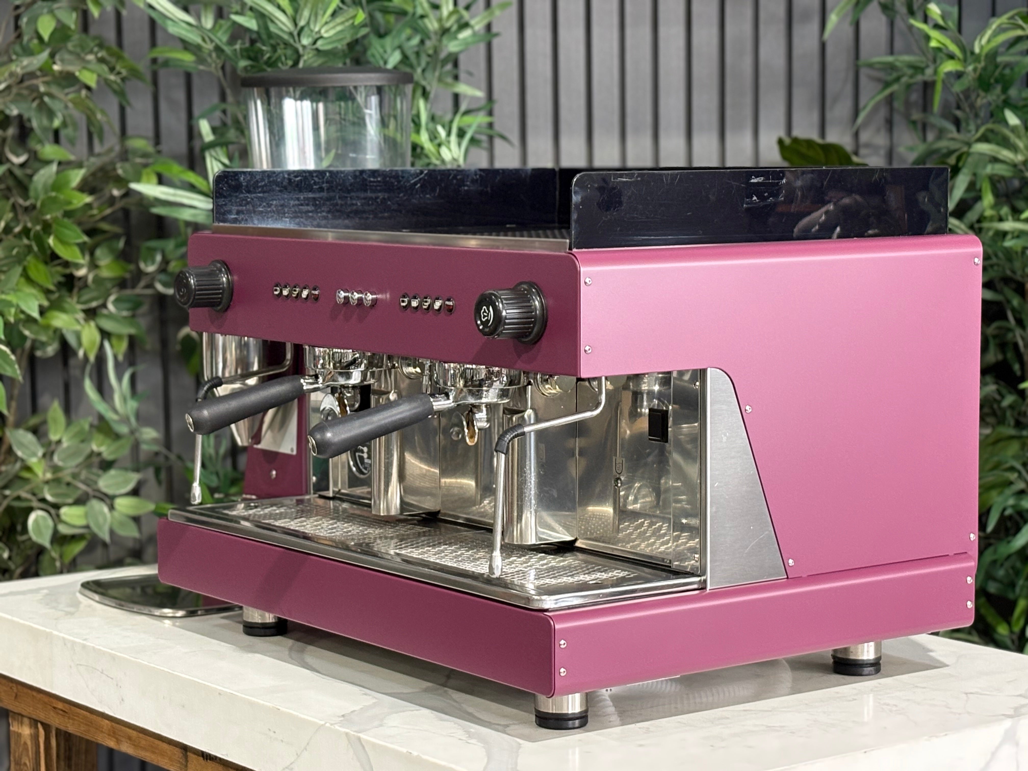 Wega Pegaso EVD 2 Group Coffee Machine & Mazzer Major Electronic Grinder Deep Pink on a counter with greenery