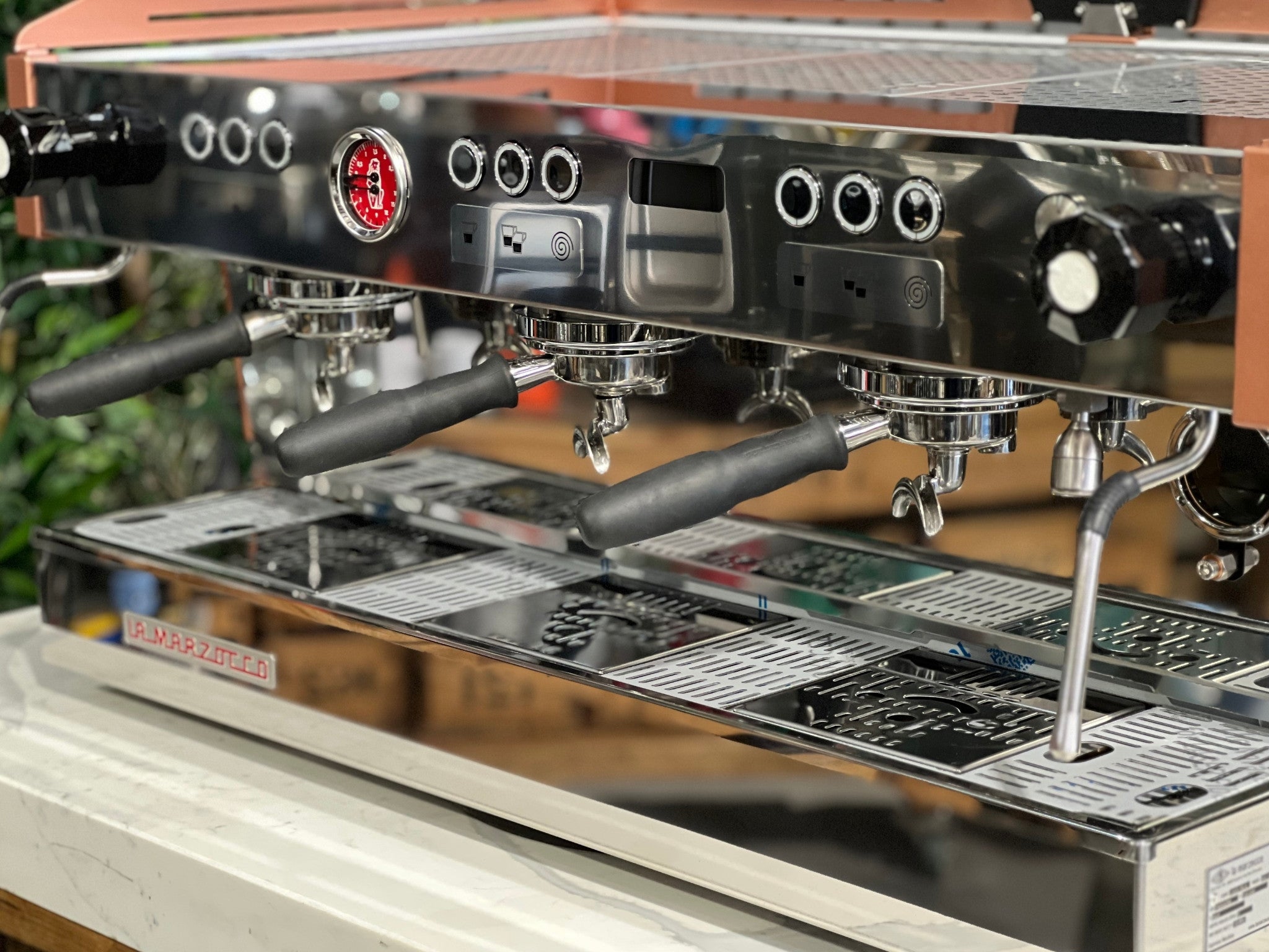 La Marzocco Linea PB ABR 3 Group Coffee Machine White & Copper - New angled close-up showing group heads, integrated ABR drip tray with scales, dual steam wands, and copper detailing, highlighting the espresso coffee machine’s white and copper body on a marble bench with greenery.