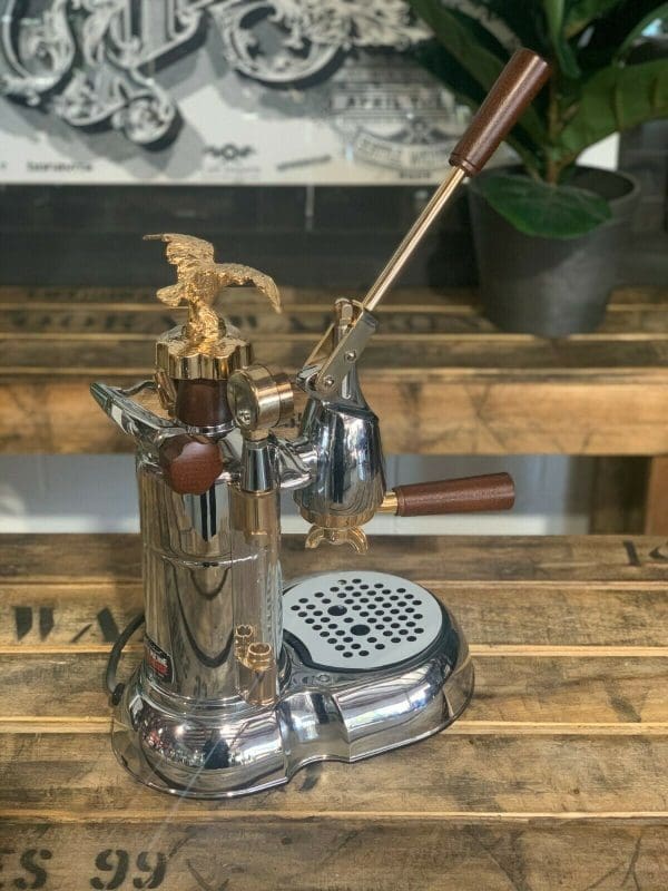 La Pavoni Expo 2015 1 Group Espresso Machine with gold accents on wooden countertop