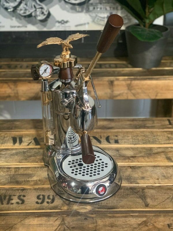 La Pavoni Expo 2015 1 Group Espresso Machine displayed on a wooden surface with elegant design features.