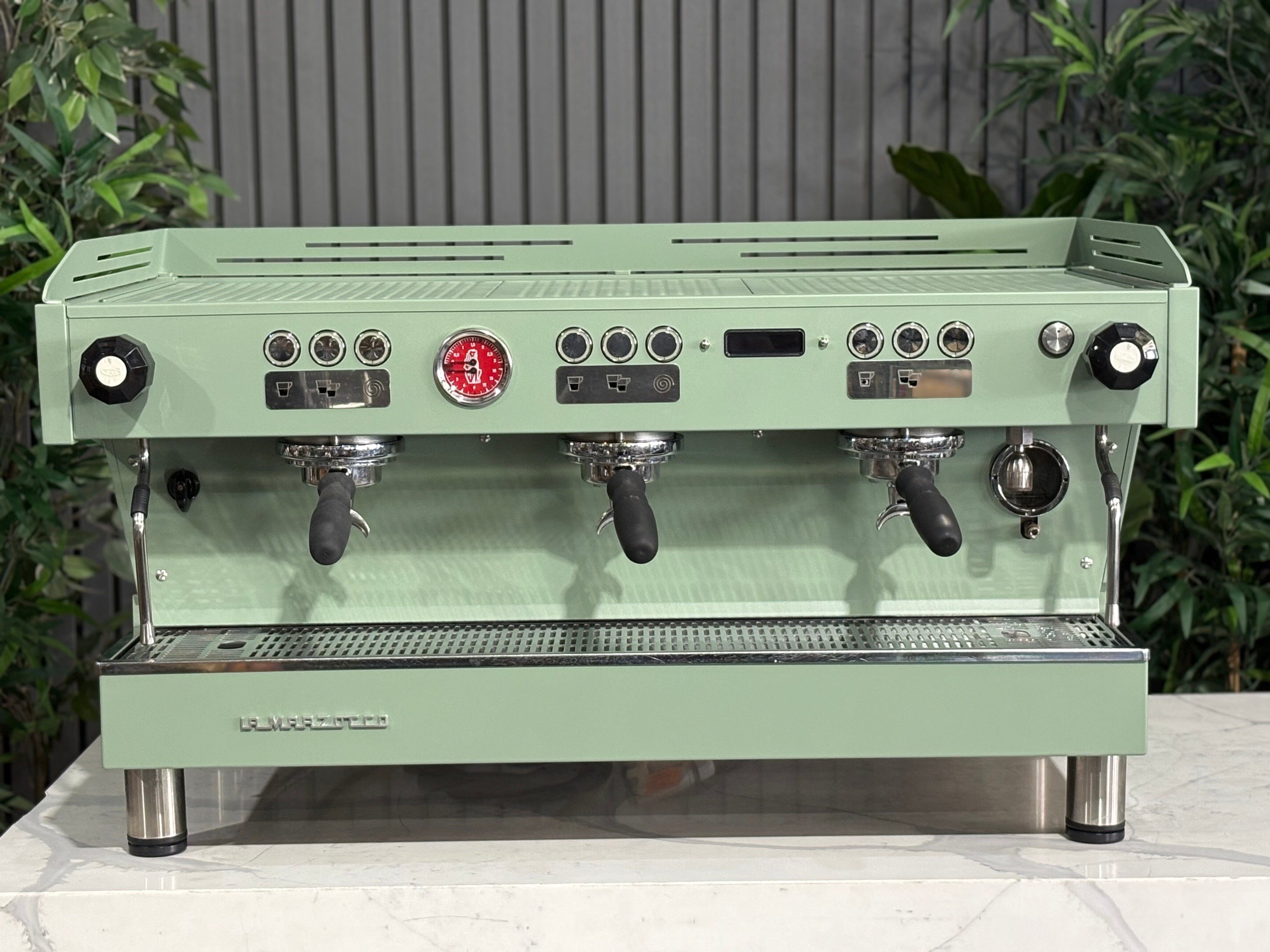 La Marzocco Linea PB 3 Group Coffee Machine Mint Green - Used displayed in a café setting with plants.