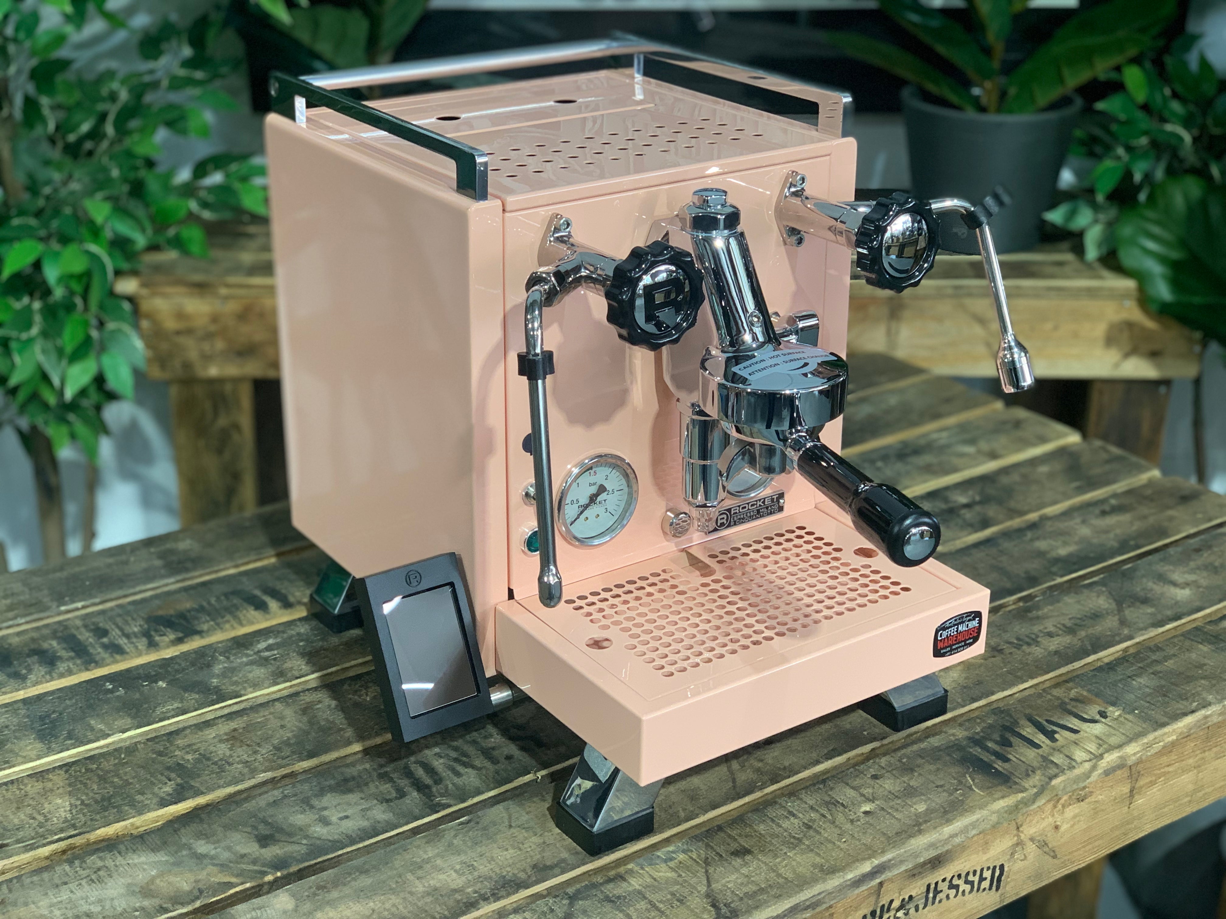 Rocket Cinquantotto R58 1 Group Coffee Machine Pink - New displayed on a wooden table with greenery in the background.
