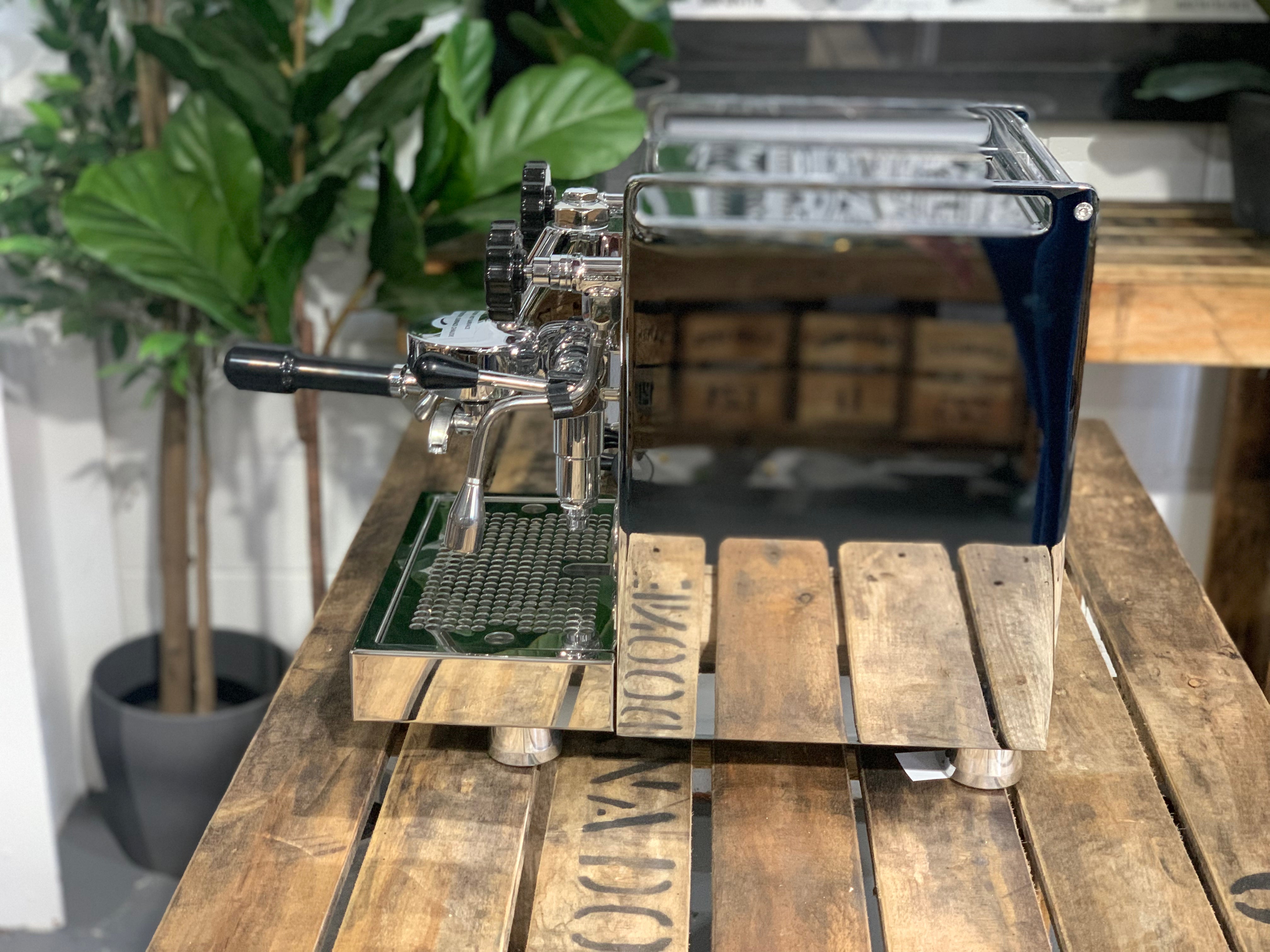 Rocket Mozzafiato Cronometro V 1 Group Coffee Machine - New displayed on a wooden table with plants in the background.