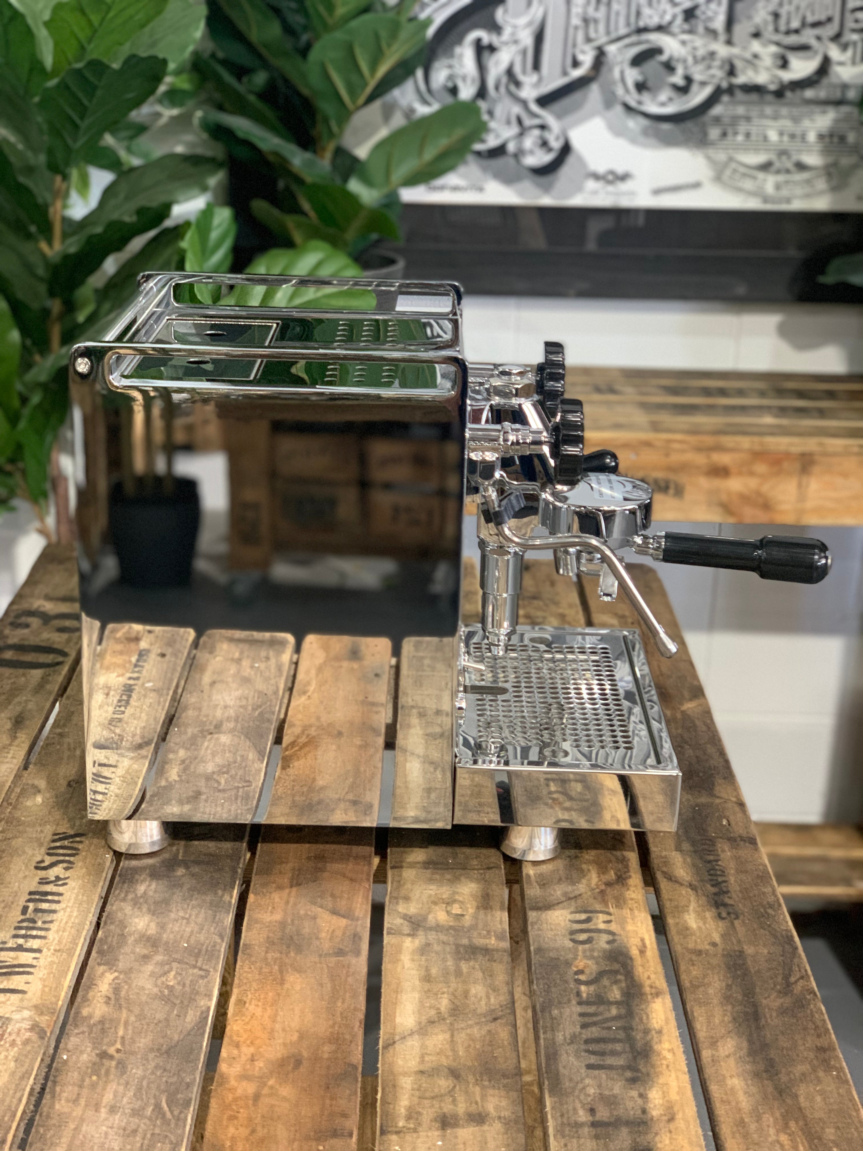 Rocket Mozzafiato Cronometro V 1 Group Coffee Machine - New displayed on wooden table with plants in background.