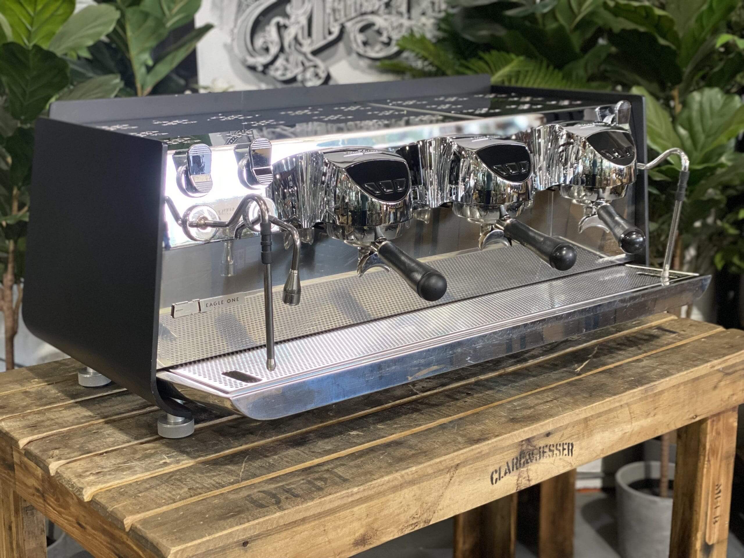 Victoria Arduino Eagle One 3 Group Black Espresso Machine - Used on a wooden table with a modern design.