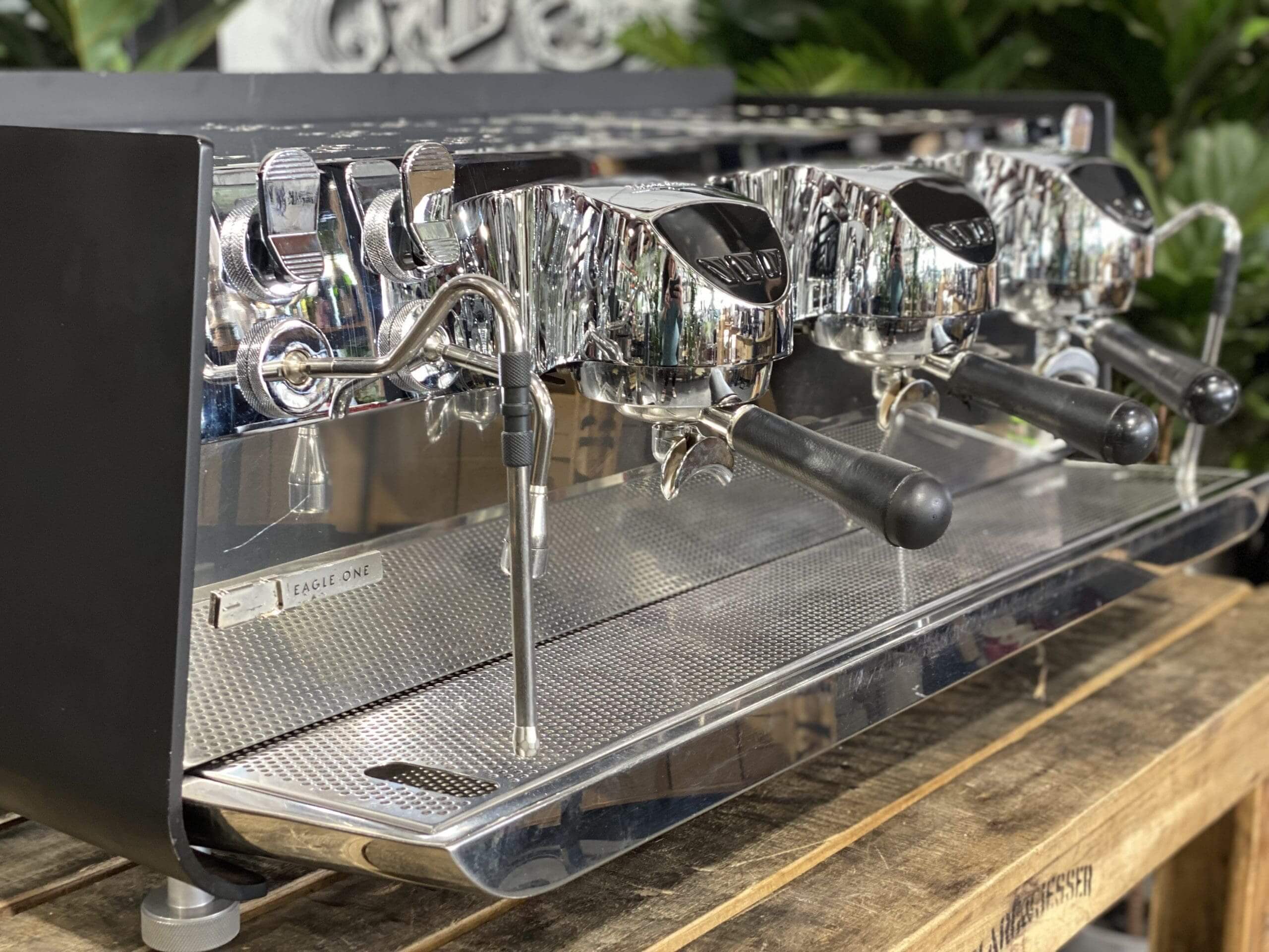 Victoria Arduino Eagle One 3 Group Black Espresso Machine showcased on a wooden surface.