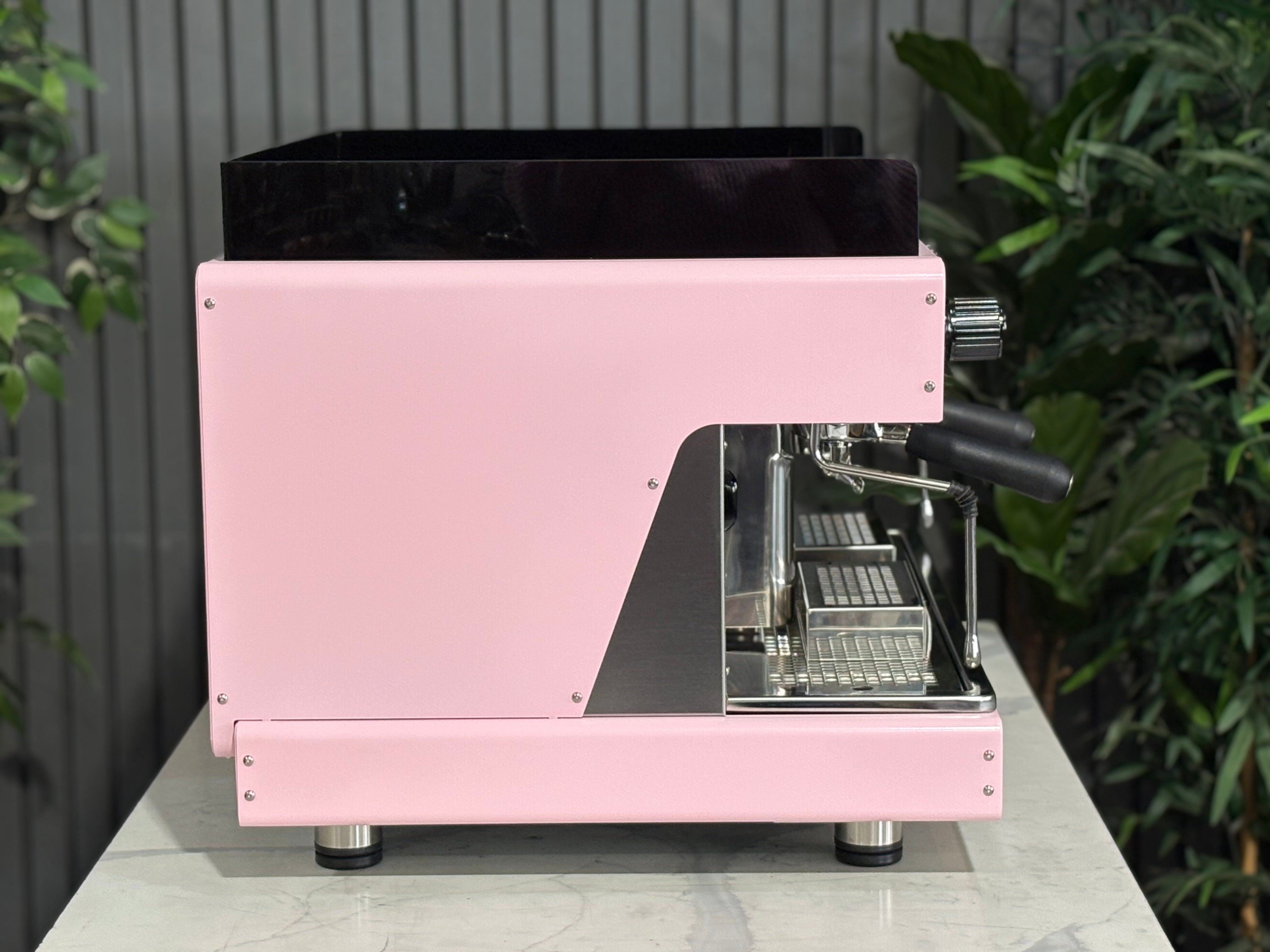 Wega Pegaso EVD 2 Group Coffee Machine Pink Lily Espresso Machine side view on a marble table with green plants in background.