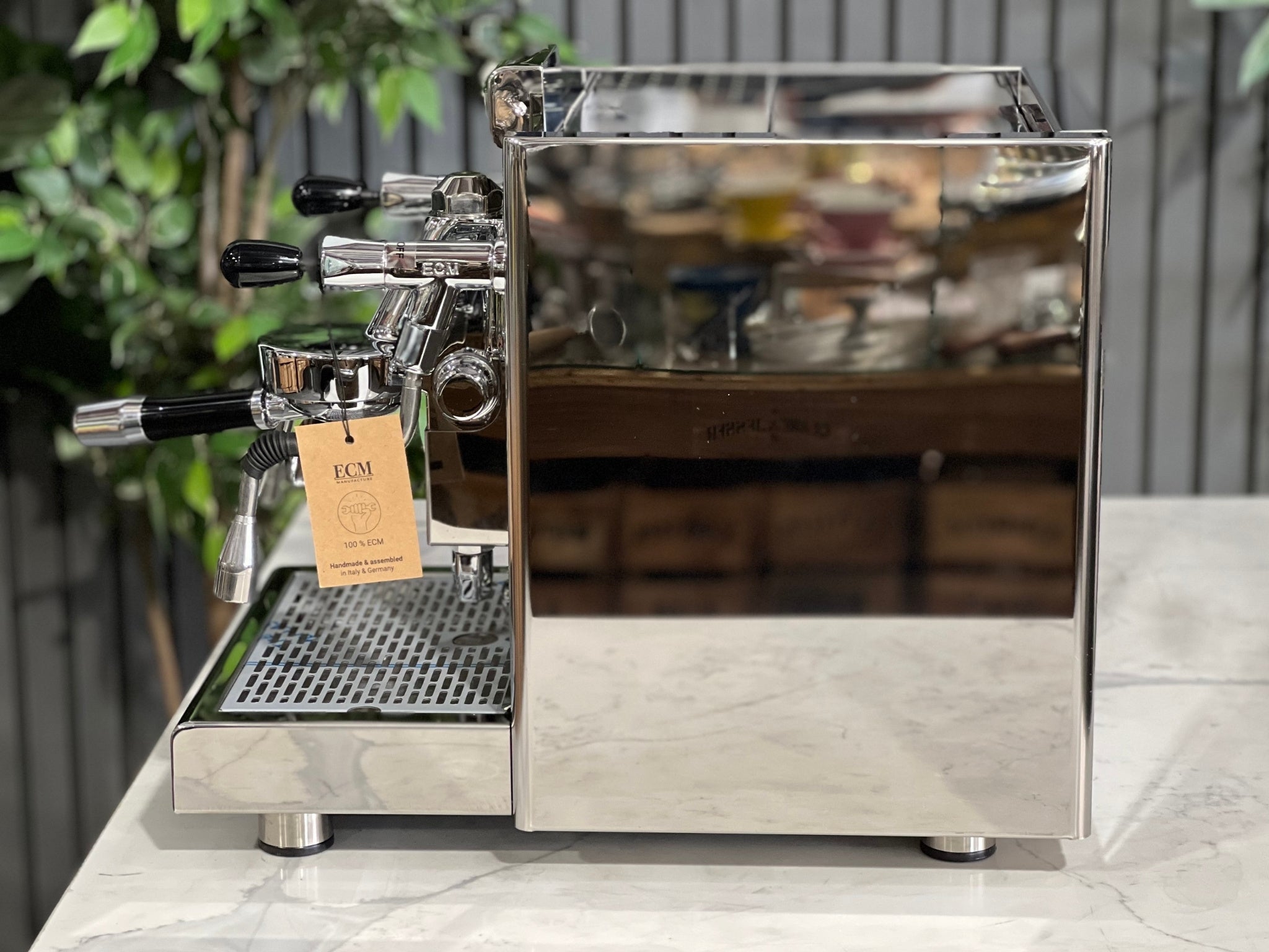 ECM Elektronika II Profi Rotary 1 Group Coffee Machine Stainless – New, side view displaying stainless steel finish, steam wand, and high cup clearance on a marble bench with greenery behind.
