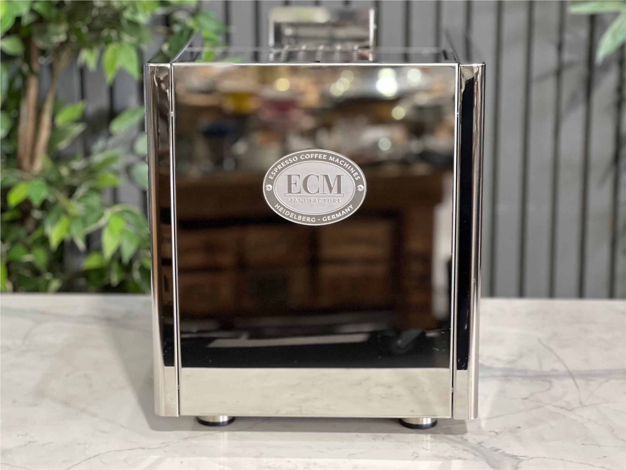 ECM Elektronika II Profi Rotary 1 Group Espresso Coffee Machine Stainless – New, rear view showing the smooth stainless steel back panel of the machine on a marble bench with greenery behind.