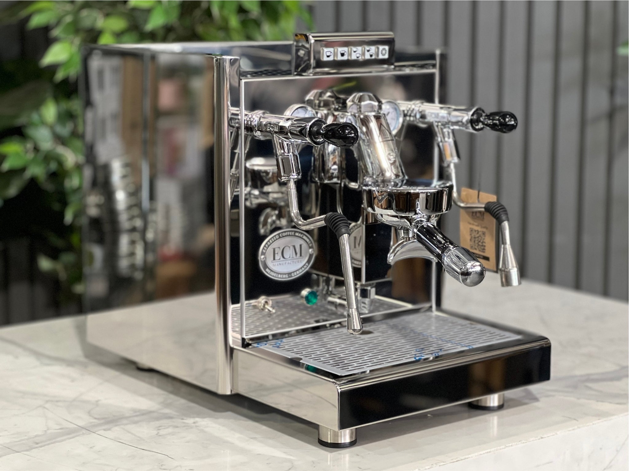 ECM Elektronika II Profi Rotary 1 Group Coffee Machine Stainless – New, angled view showing stainless steel body, E61 group head, steam wand, and cup warmer on a marble bench with greenery behind, perfect for a home espresso setup.
