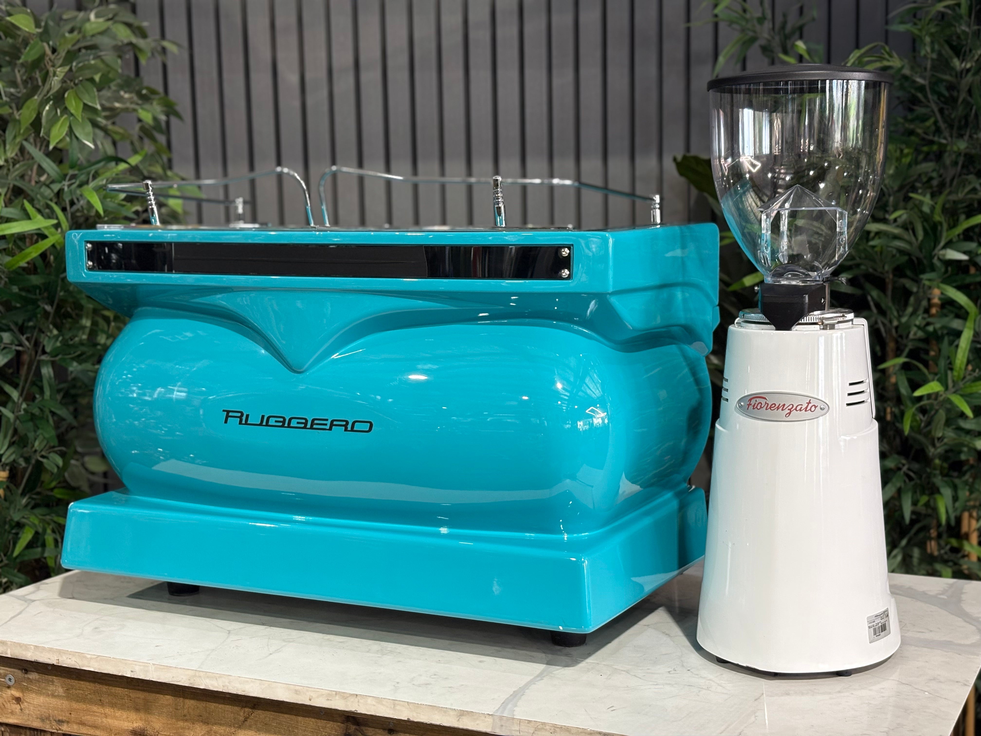 Expobar Alfa Ruggero 2 Group Coffee Machine & F83 Electronic Grinder in teal and white on display.
