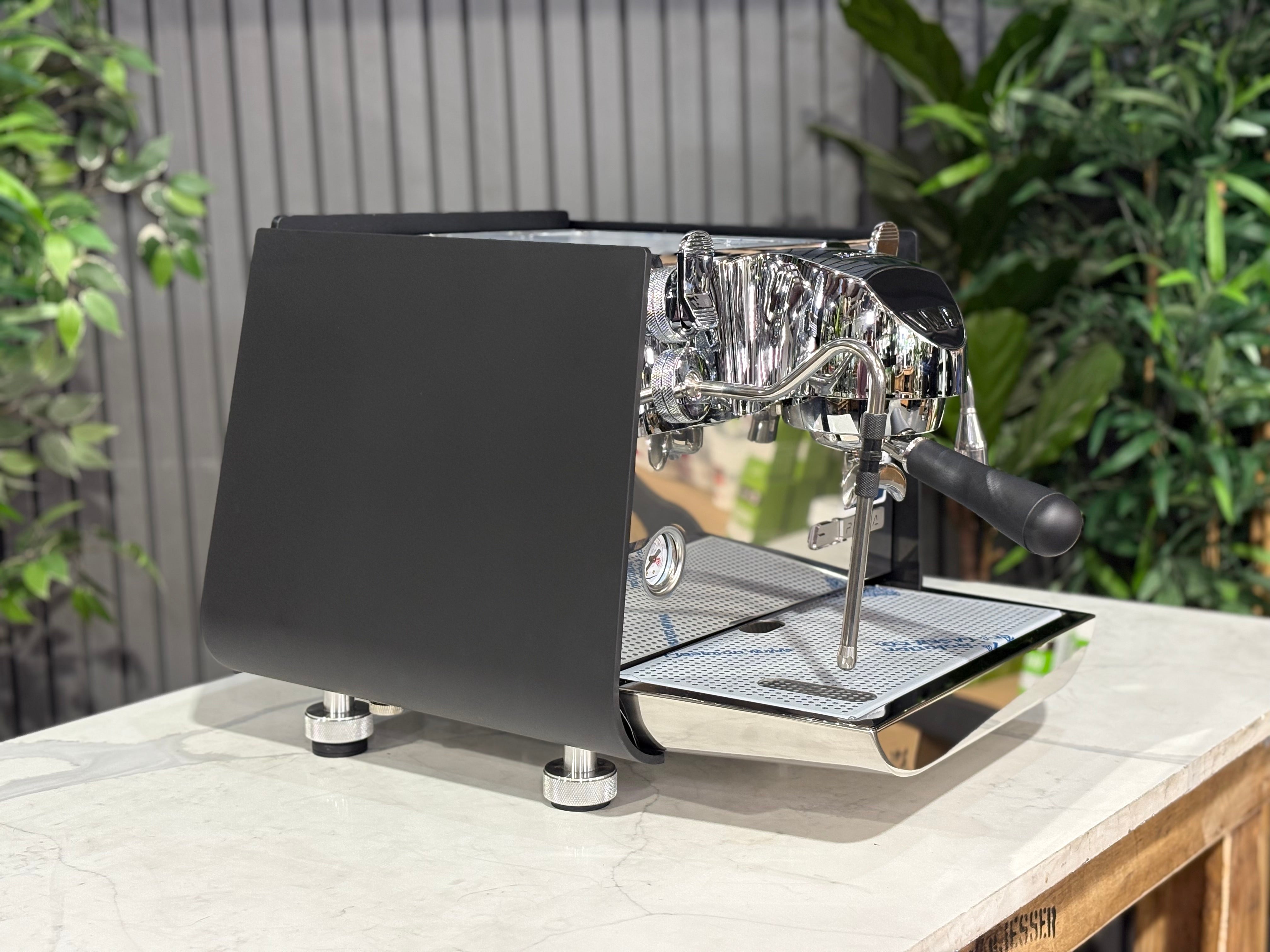 Victoria Arduino Eagle One Prima 1 Group Coffee Machine Black - New side view on a countertop with plants in background.