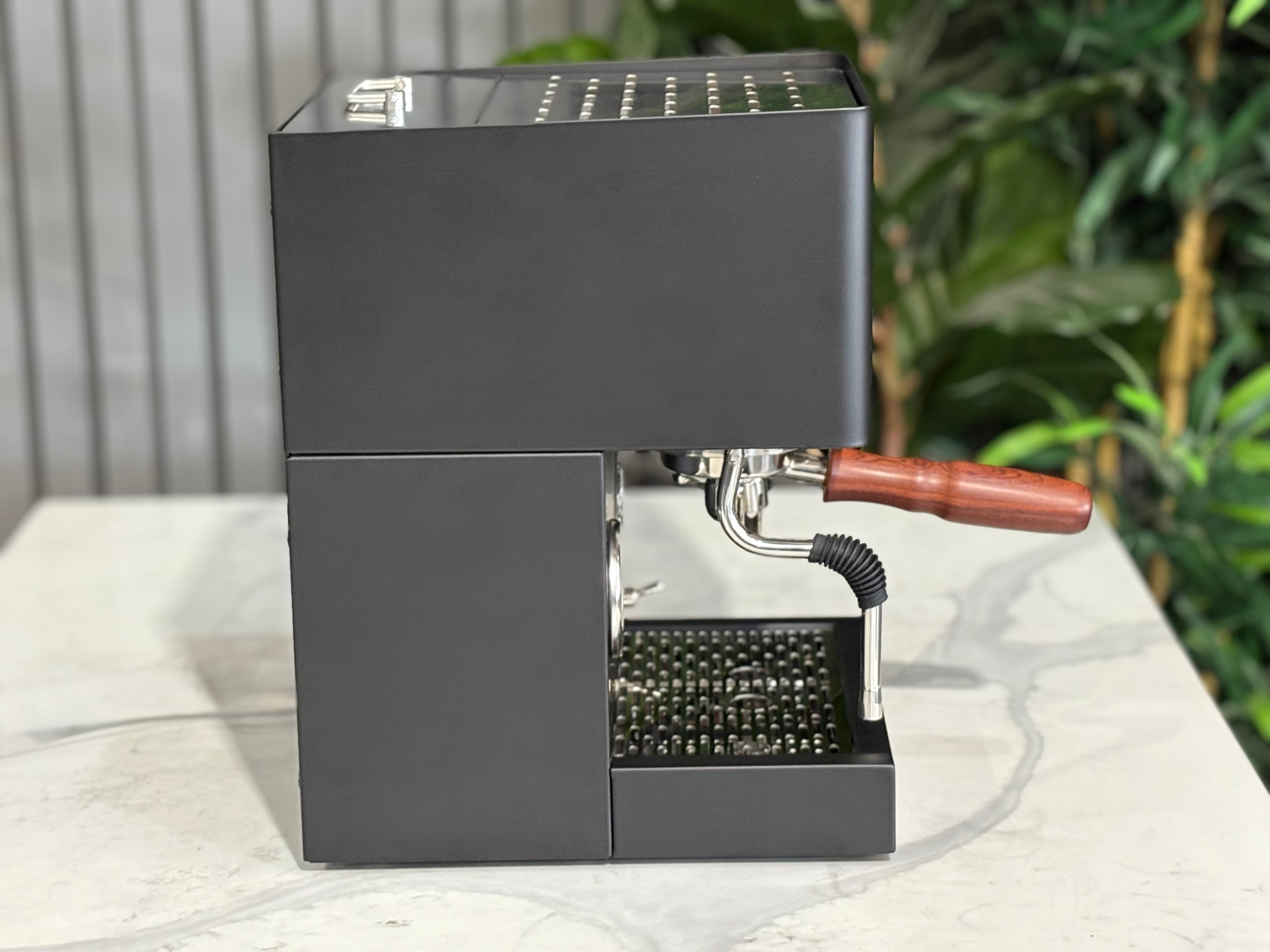 Essenza Nina 1 Group Coffee Machine Stainless in sleek black design on a marble countertop.