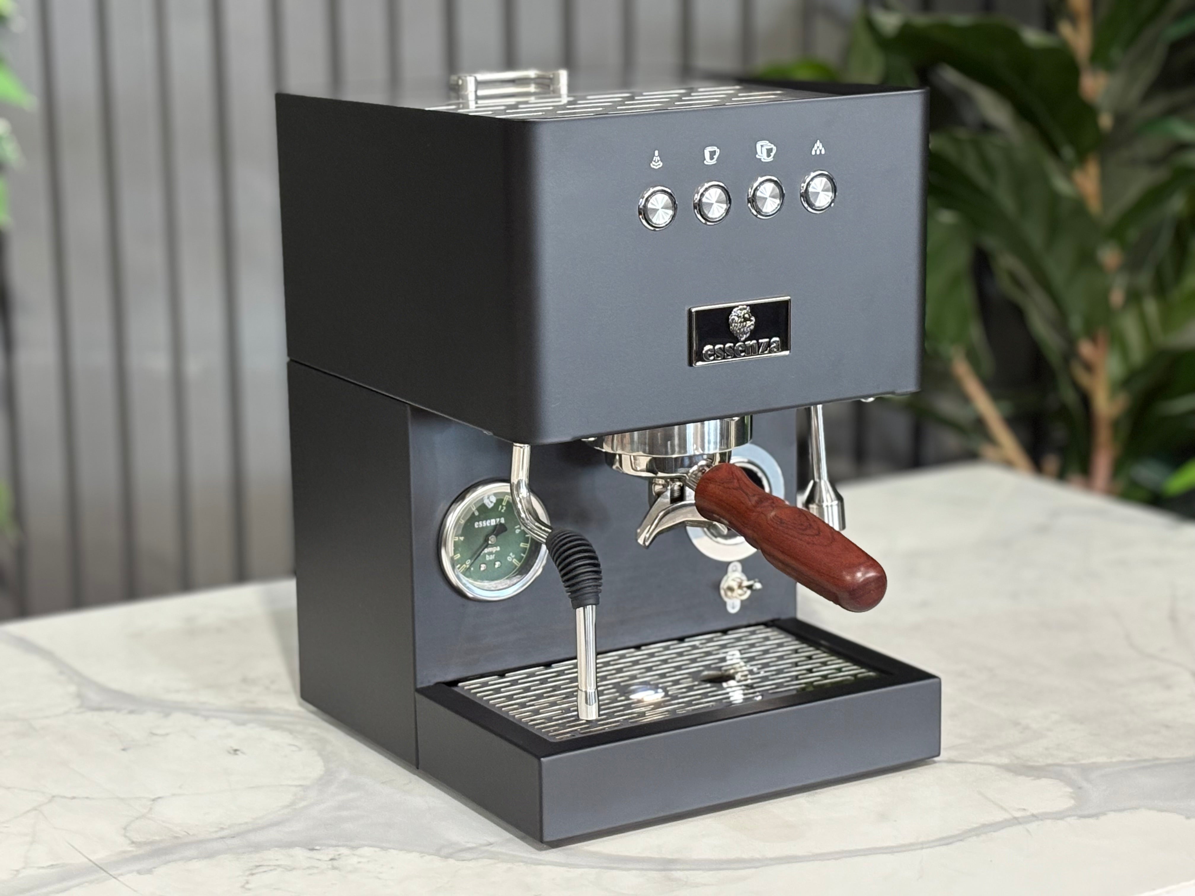 Essenza Nina 1 Group Coffee Machine Stainless viewed from the side on a marble countertop in a modern setting.