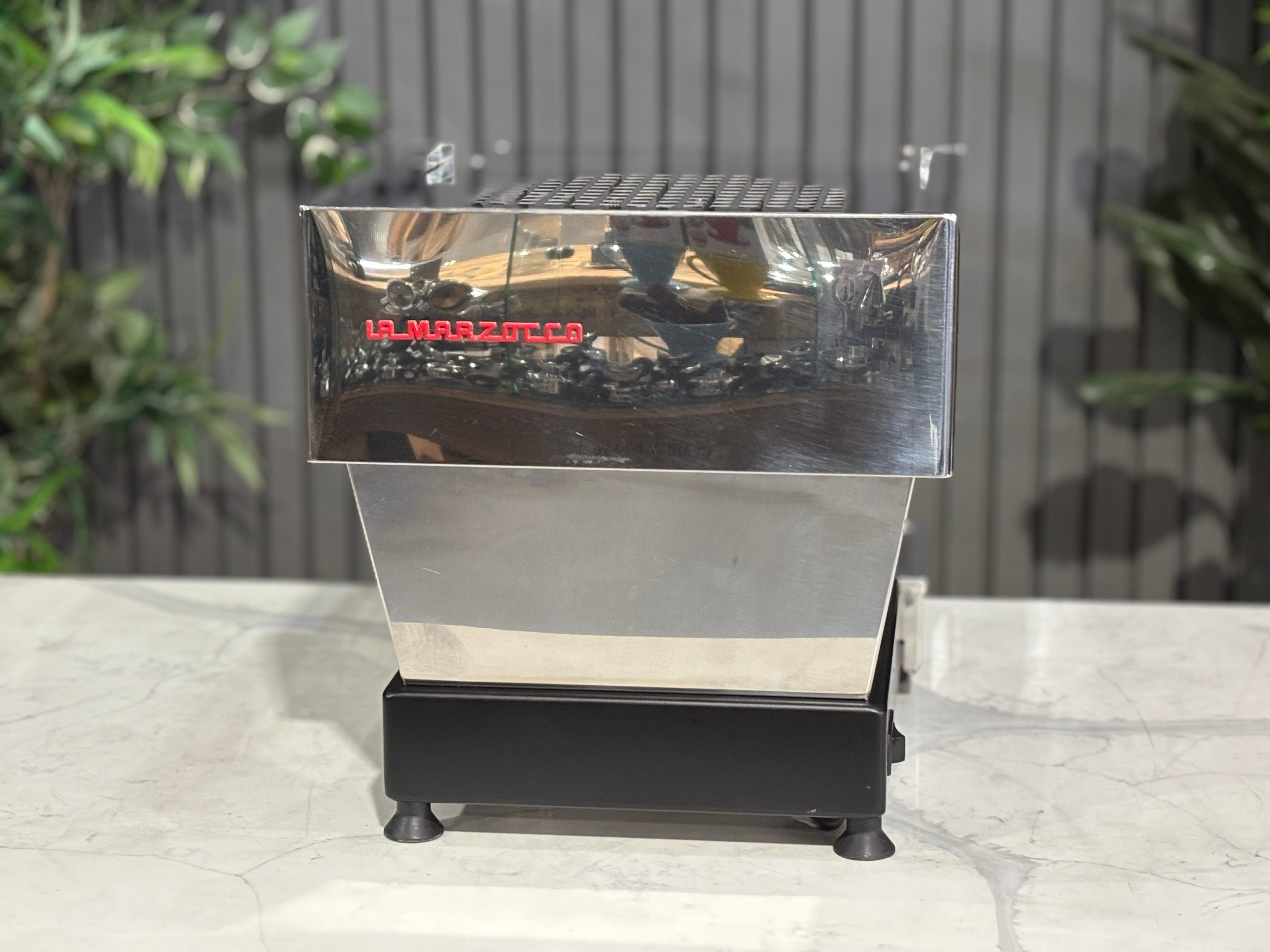 La Marzocco Linea Mini MP 1 Group Coffee Machine Stainless - Used displayed on a marble counter with plants in the background.