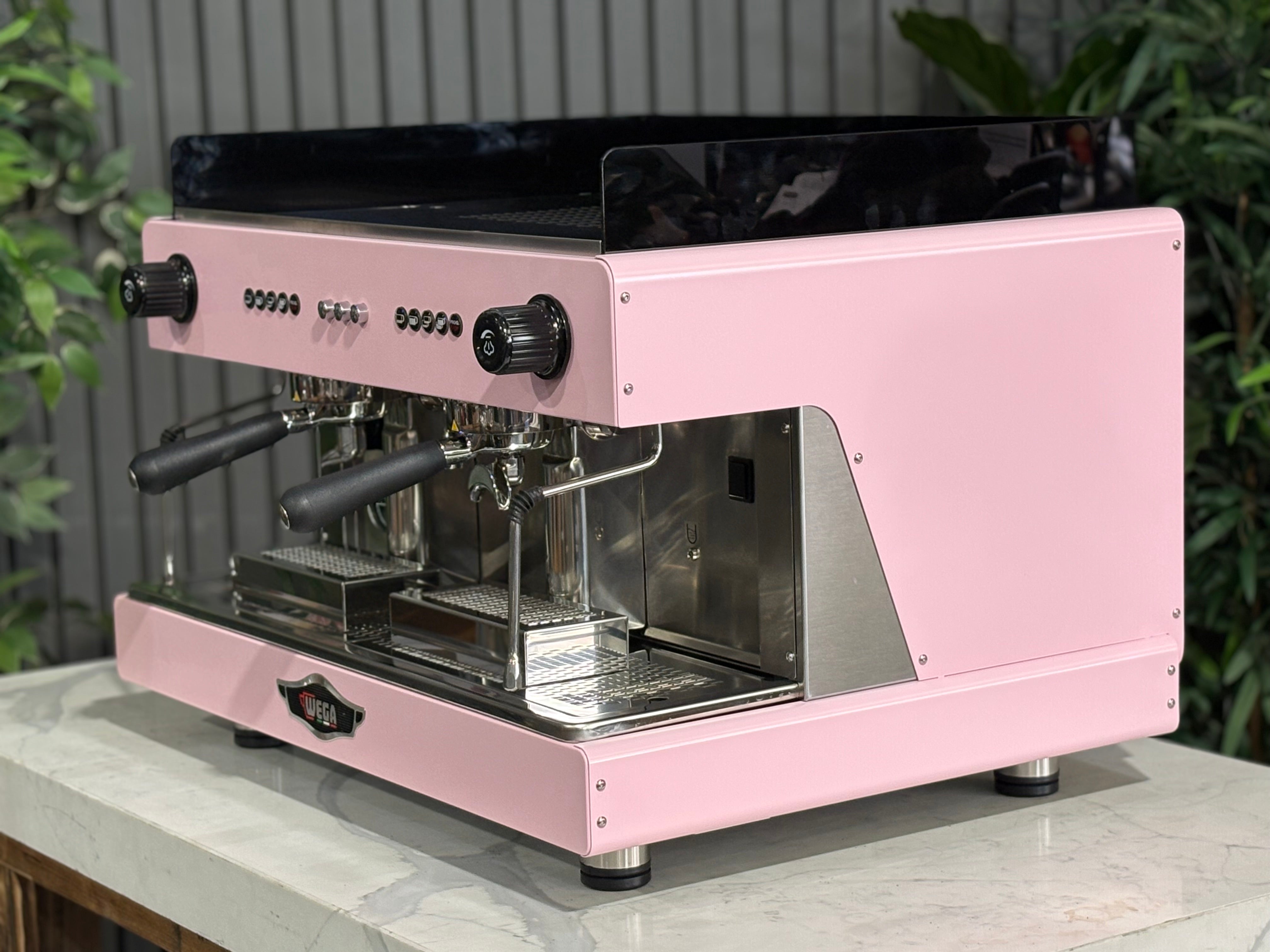 Wega Pegaso EVD 2 Group Coffee Machine Pink Lily Espresso Machine displayed on a table with plants in the background.